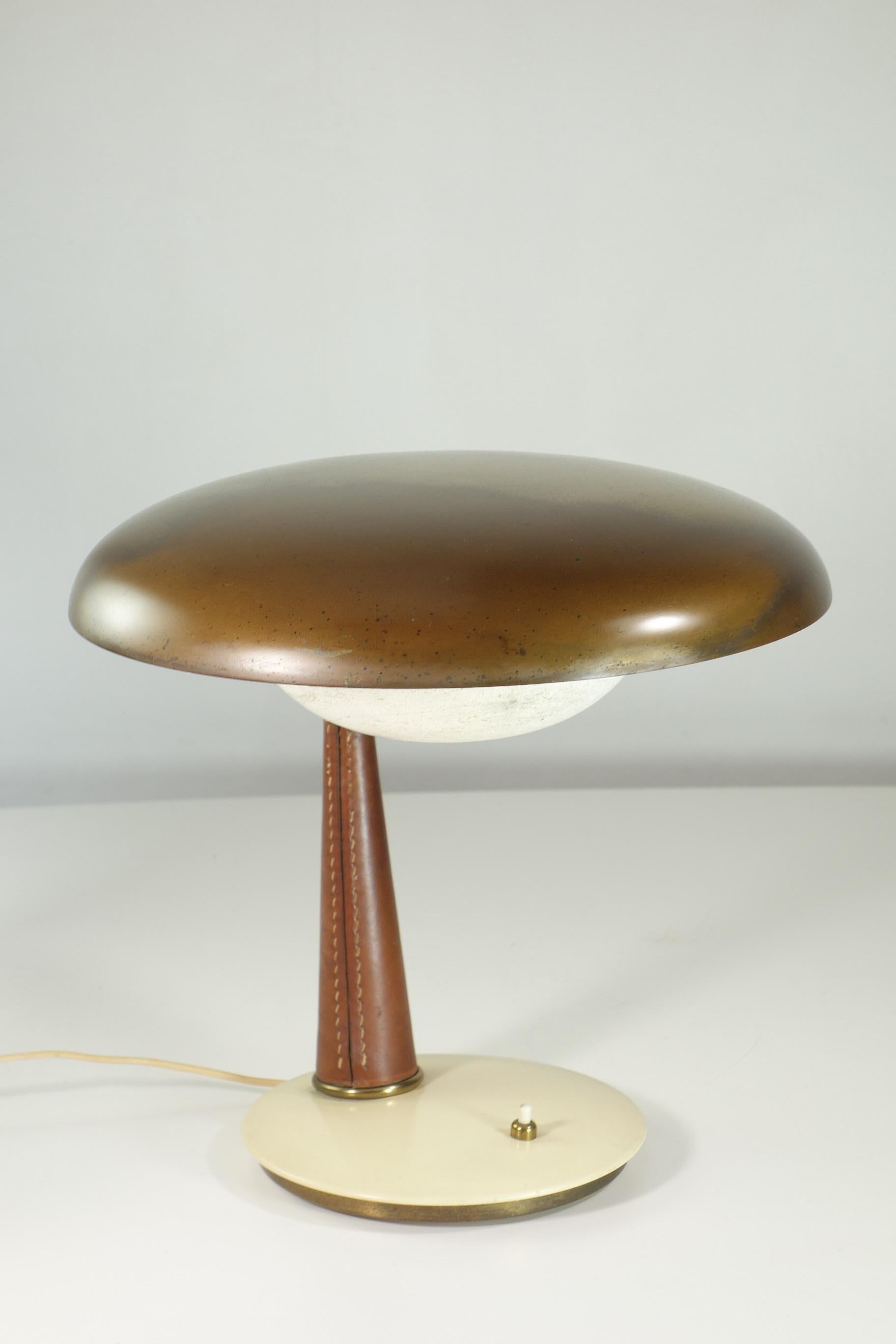 Tischlampe
Angelo Lelii
Arredoluce
Italien, 1956 ca.

Aluminium-Emaille, Leder, Messing und mattiertes Glas

Messing mit originaler Patina
Keine Risse.
Perfektes Funktionieren
Original 1950er Jahre