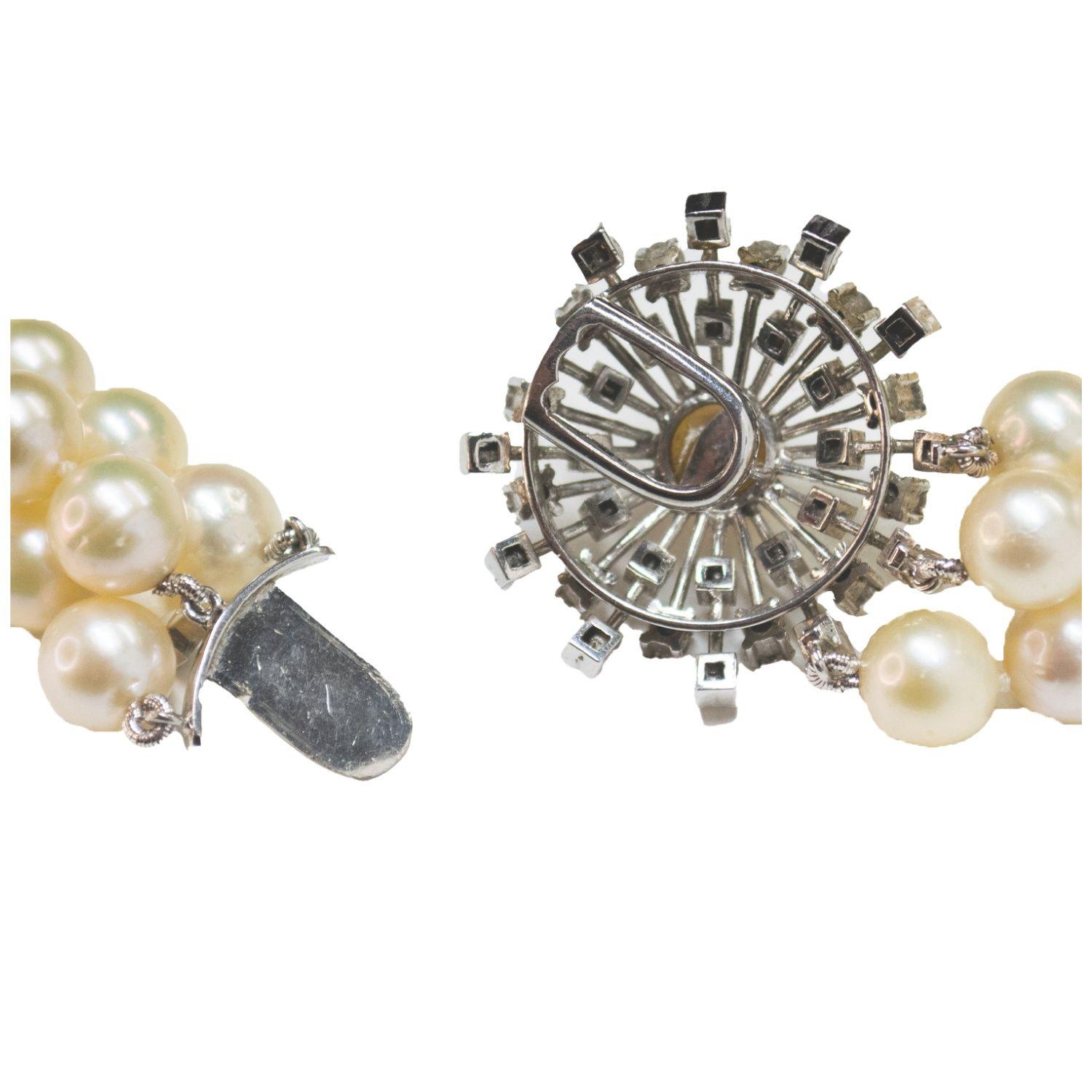Elegant 1950s contemporary design necklace composed of three strands of cultured pearls and a refined 18k yellow gold clasp adorned with antique- and brilliant-cut diamonds. A timeless statement piece combining classic beauty with mid-century