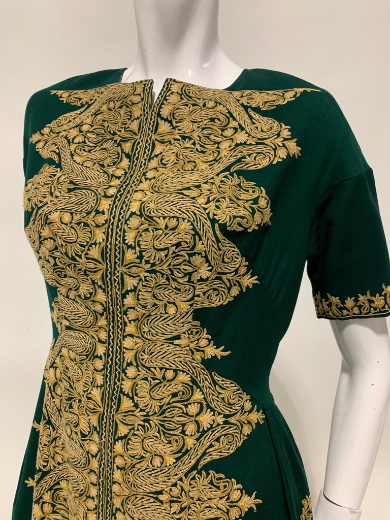 An unusual 1950s custom-made mid-length sleeved forest green wool day dress with gold-tone corded crewel embroidery covering the entire front of dress. Traditional crafted style embroidery brought into the 20th century. Skirt has a faux underskirt