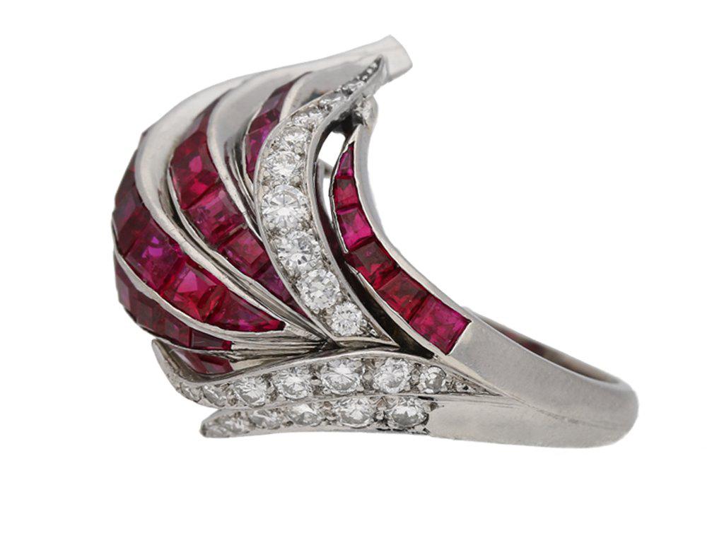 Ruby and diamond cocktail ring. Set with fifty three tapered baguette cut natural unenhanced rubies in open back channel settings with a combined approximate weight of 7.50 carats, further set with thirty nine round brilliant cut diamonds in open