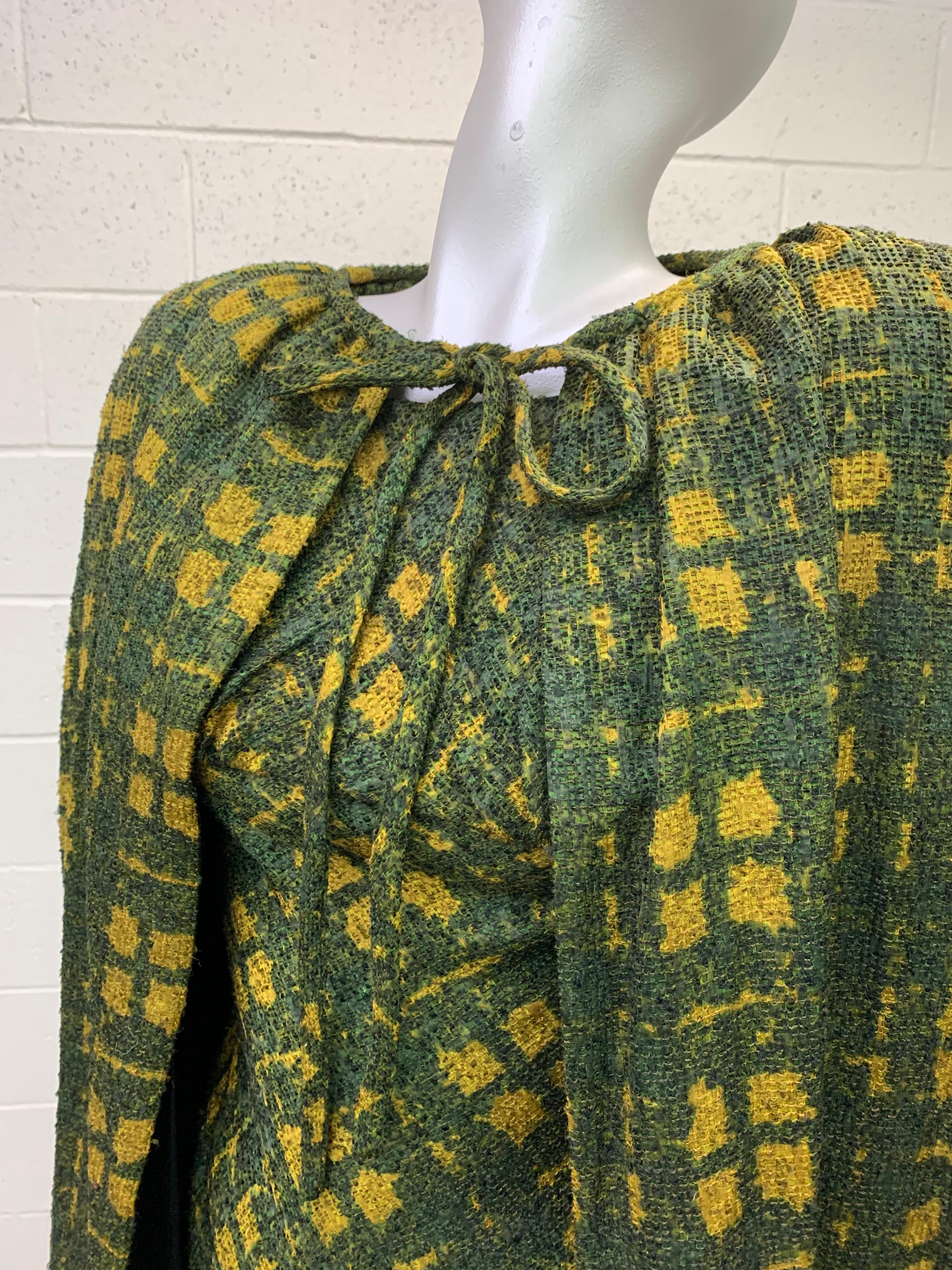 An exquisite 1950s James Galanos olive green and mustard plaid fine wool boucle woven dress and cape ensemble:  Dress is long-sleeved and cut on the bias with a gathered boatneck neckline. Olive silk dress lining. Side zipper on dress. Size 6. The