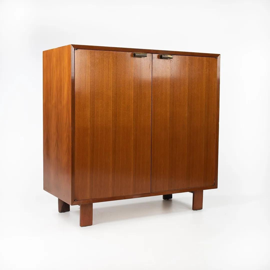 Listed for sale is a two-door cabinet designed by George Nelson and produced by Herman Miller circa 1950. This is a gorgeous original example, which appears remarkably intact. As noted in the photos, the cabinet has two pull-out drawers and