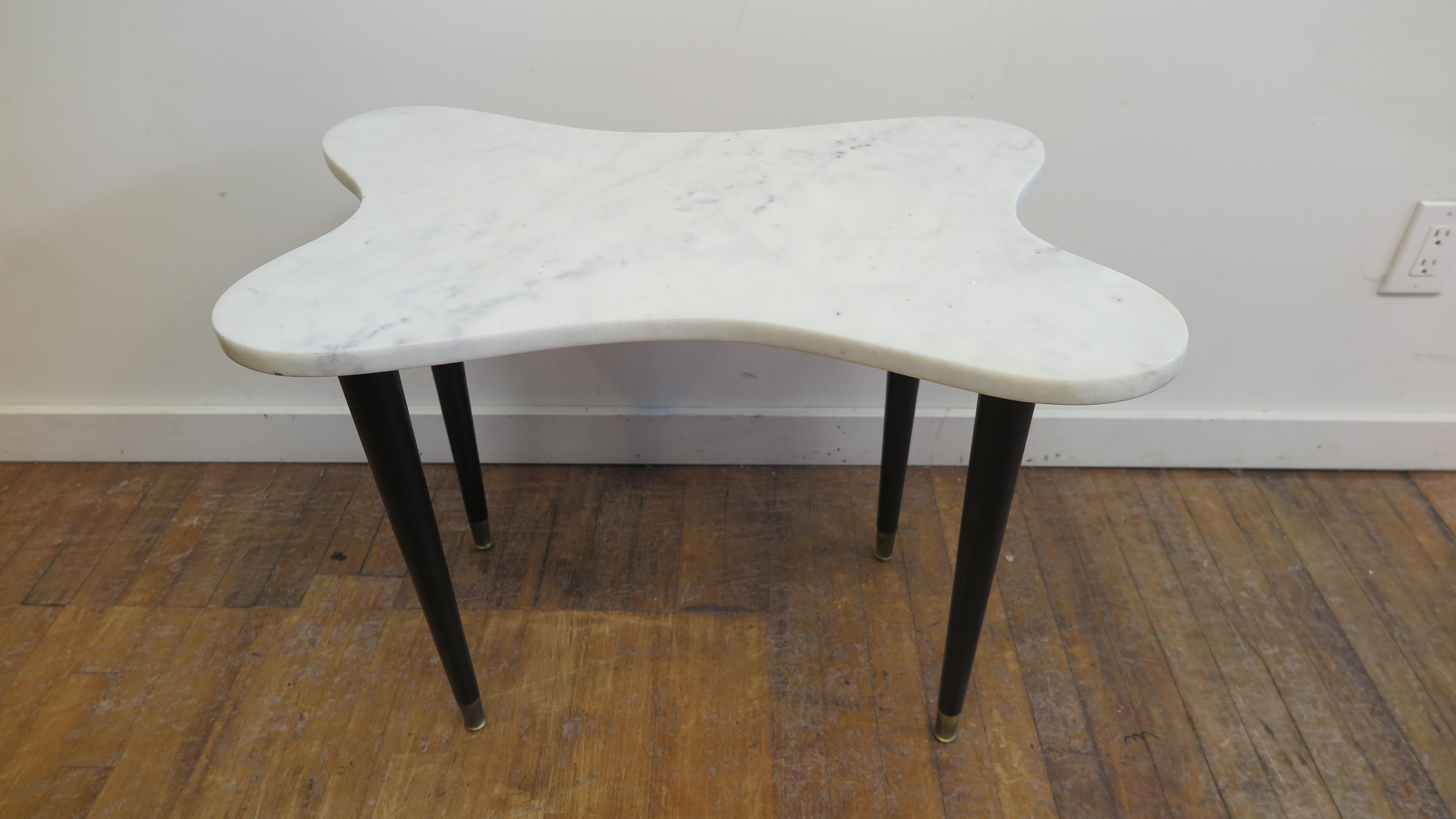 Mid-century Modern Italian marble top table biomorphic shape on 4 tapered black lacquered legs with brass sabot feet. Italian mid century biomorphic carrara marble side table and or cocktail table. The table size is very flexible as side, end, or