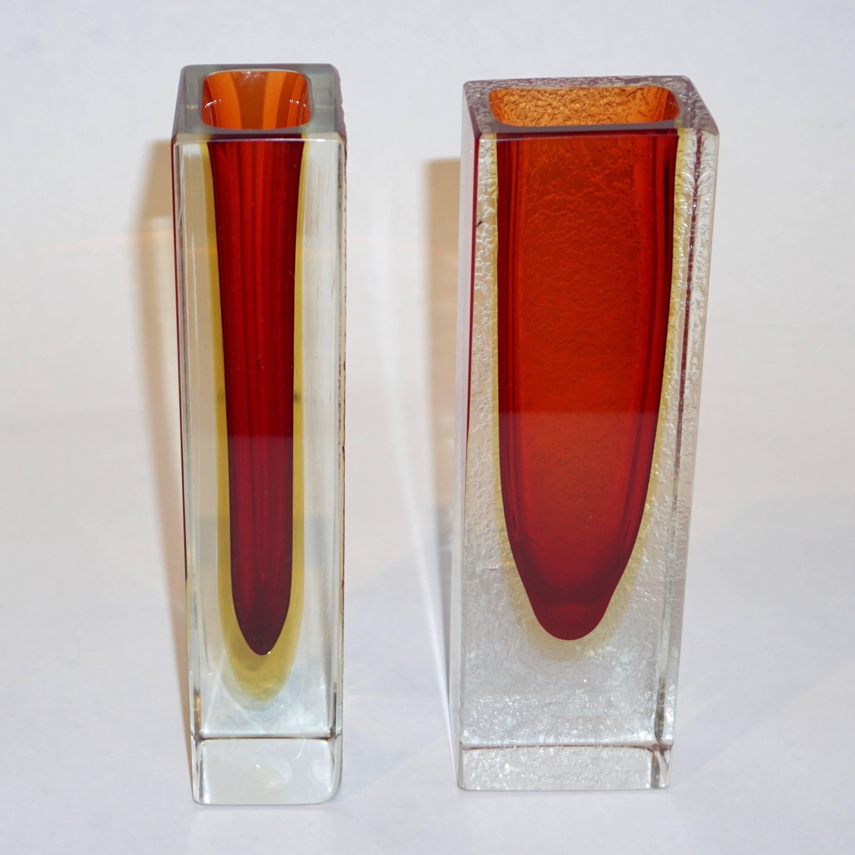 A pair of organic Murano glass vases of clean rectangular modern shape, attributed to Seguso, the linear design enhanced by the triple Sommerso technique: the crystal clear blown glass encases a layer of yellow glass and a red core with sun orange