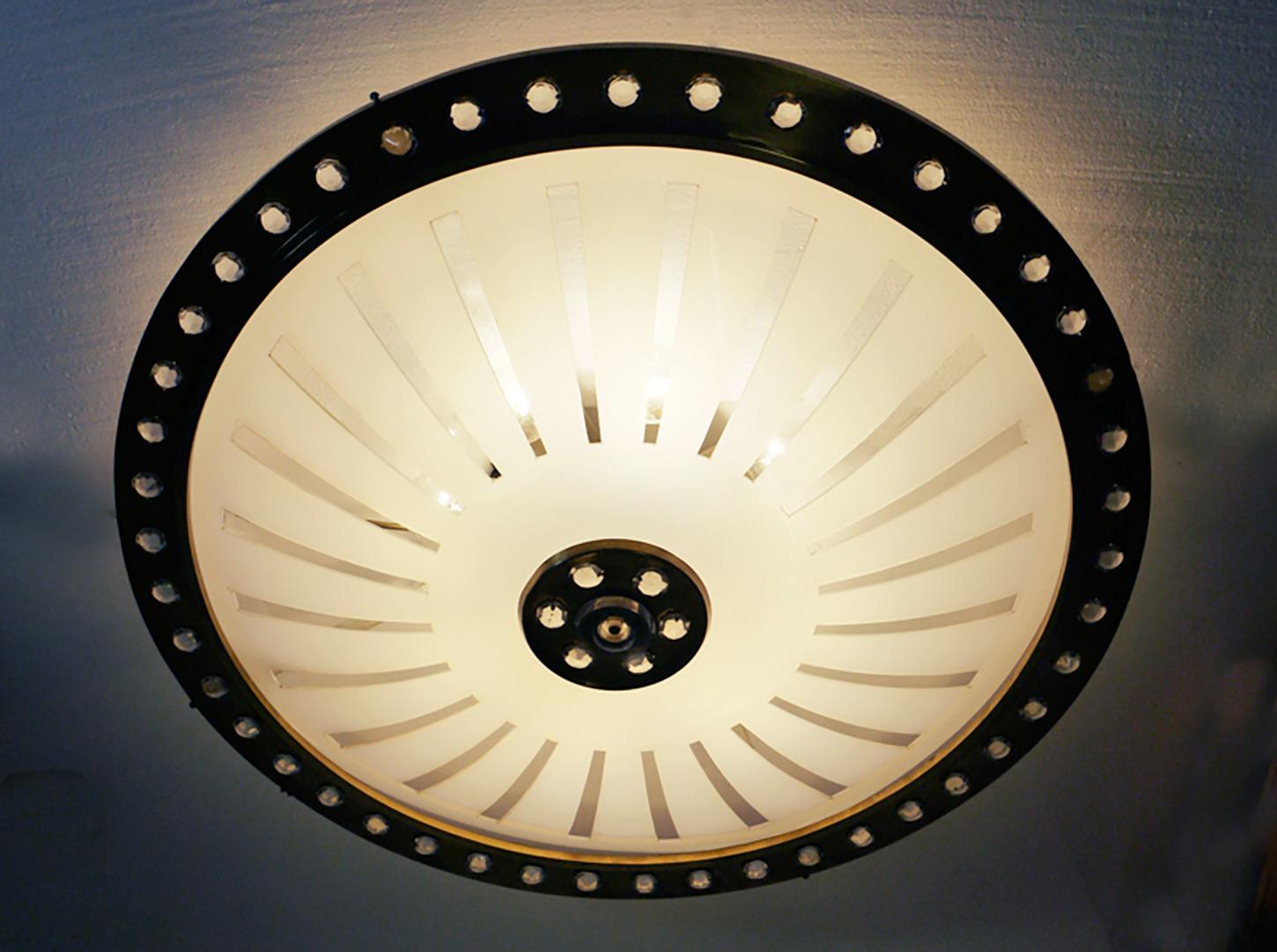 Lampada da incasso a forma di disco volante sovradimensionato con un paralume in lucite curvo extra large in una struttura in ottone decorata con perle di cristallo ottagonali che sorreggono le otto prese. Il lampadario brilla meravigliosamente e