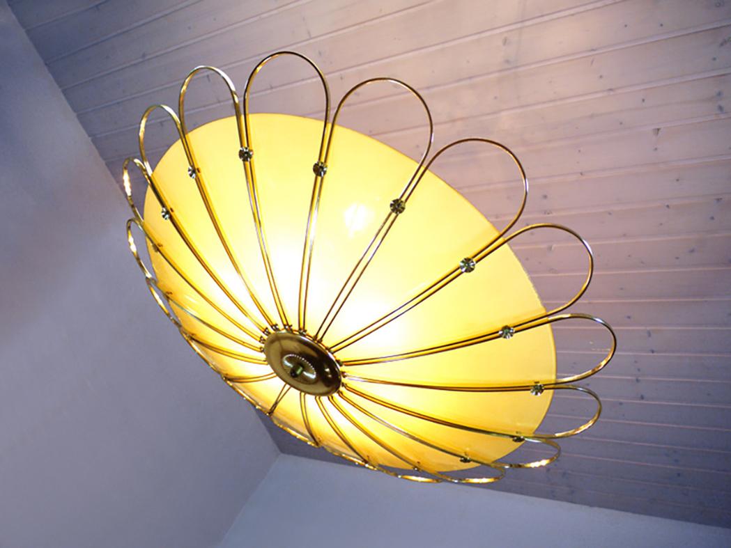 Unique oversized flying saucer semi flush mount lamp with a extra large curved glass shade in a brass petal bowl which holds the six-socket cluster. Chandelier illuminates beautifully and offers a lot of light. Gem of the time. 
 
Manufactured by