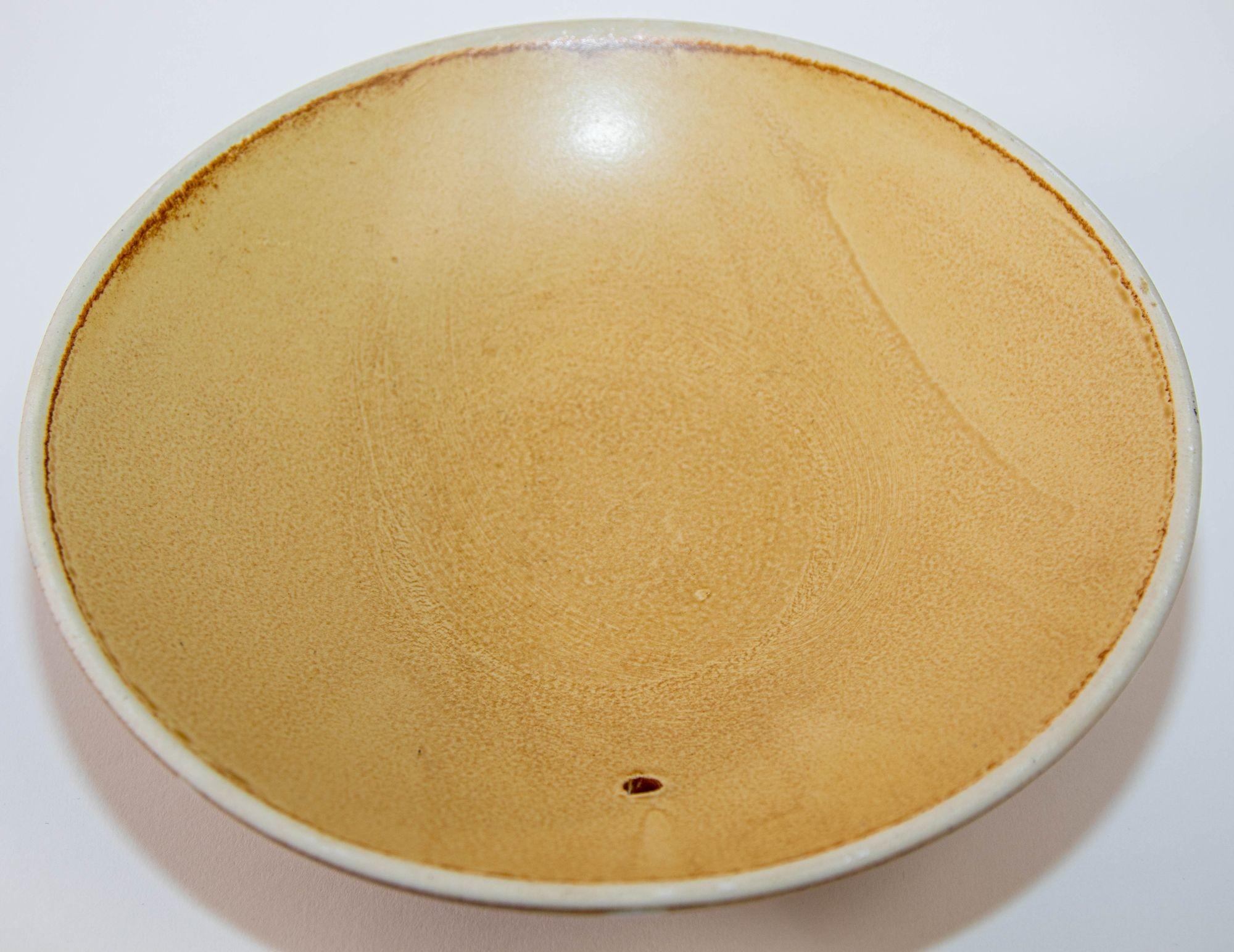 Vintage Mid Century Japanese Pottery Shallow Footed Bowl Wabi Sabi Honey Color 10 inches Diameter.
Circa 1950, Made in Japan.
Poterie artisanale japonaise couleur miel sur le dessus avec des lignes géométriques crème et marron foncé sur le dessous,