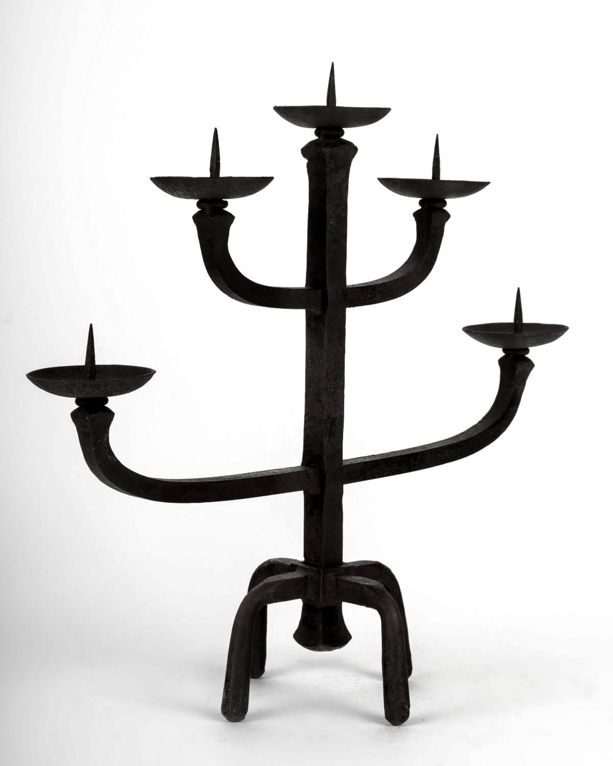 Pair of five-branch wrought iron candlesticks by Jean Touret from the Marolles workshop, handmade in France in the 1950s.

The candlesticks rest on four square feet that flare outwards towards the bottom. Above, the square central stem is decorated