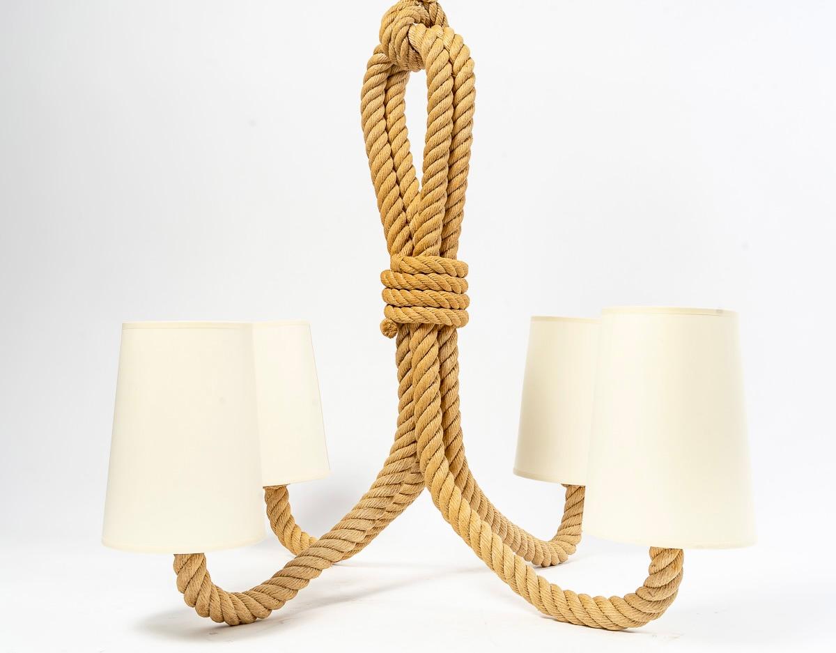Composed of two large arms of lights in folded rope on the upper part, they go down by forming two long loops assembled by rope threads then flare on the lower part to form the four arms of rising light.
They are dressed with 4 lampshades in
