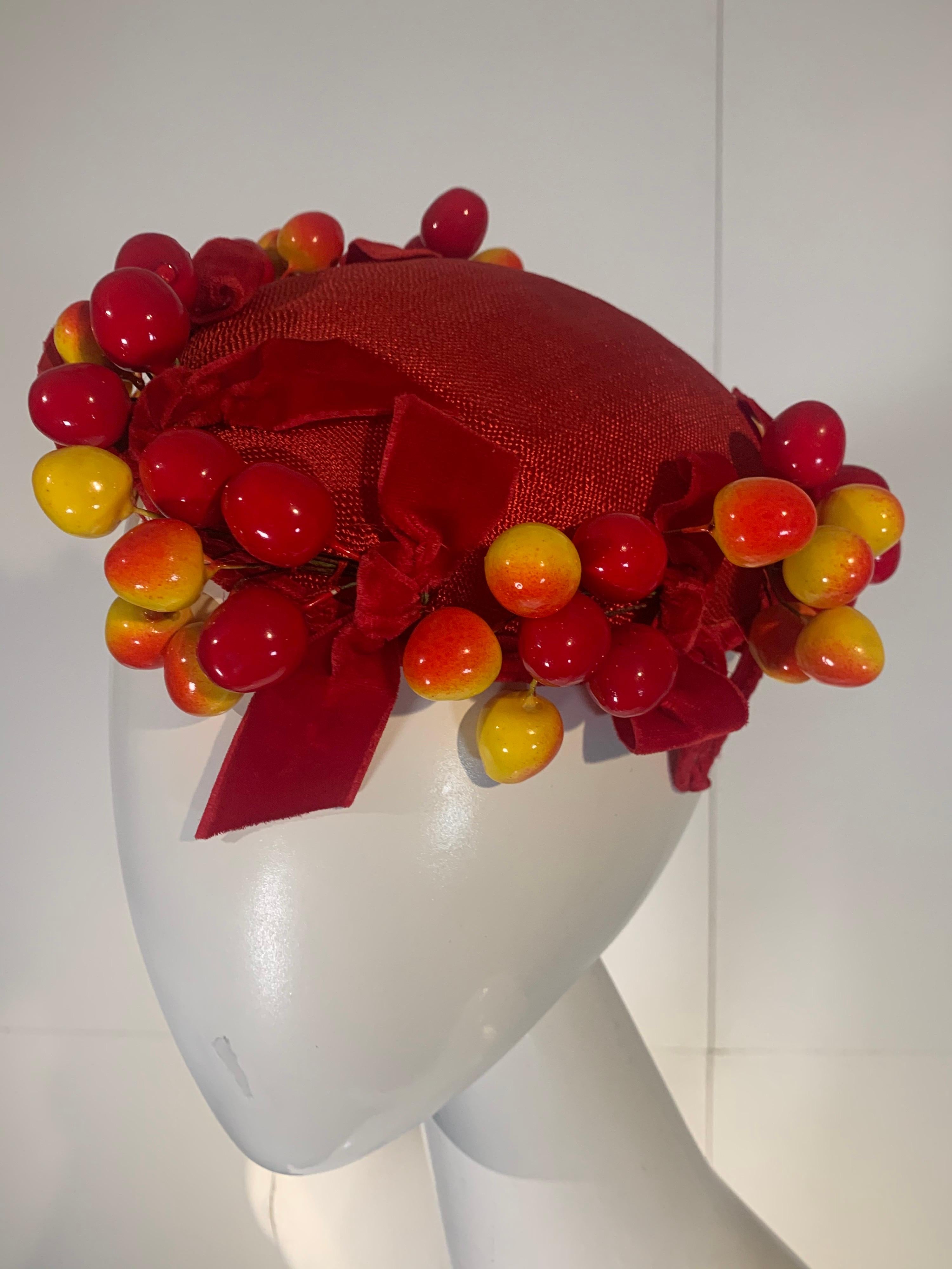 A delicious 1950s scarlet red straw topper hat adorned with blushing Merten cherries and red velvet bows. Styled by Frances. Side tabs for pinning. So charming! One size. 