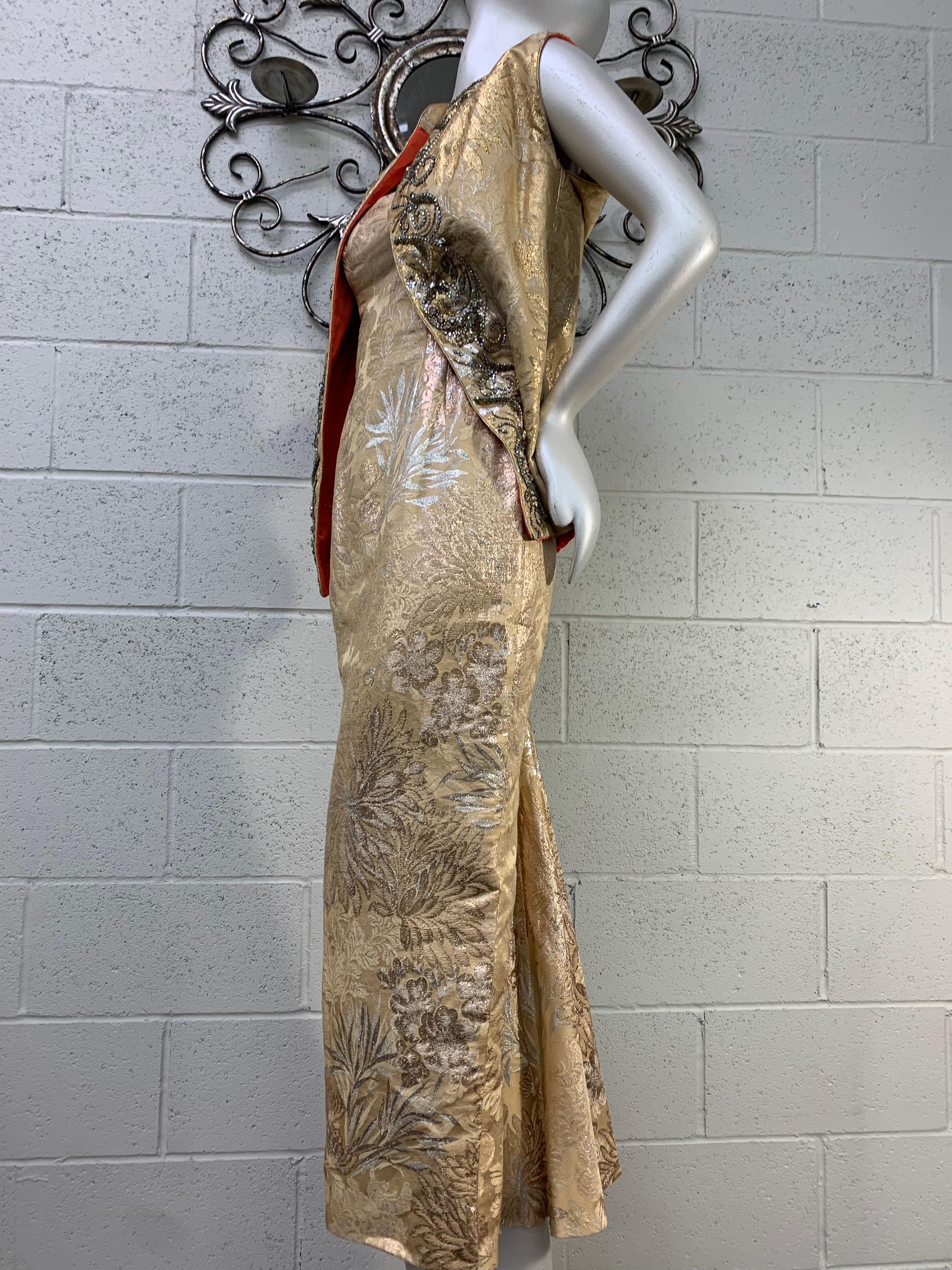 1950s Mr. Blackwell gold lame brocade fishtail sheath gown with incredible tailoring for that trademark Mr. Blackwell hourglass silhouette. Draped at center back of skirt. A vest to match which is beaded and rhinestone encrusted. A flash of vivid