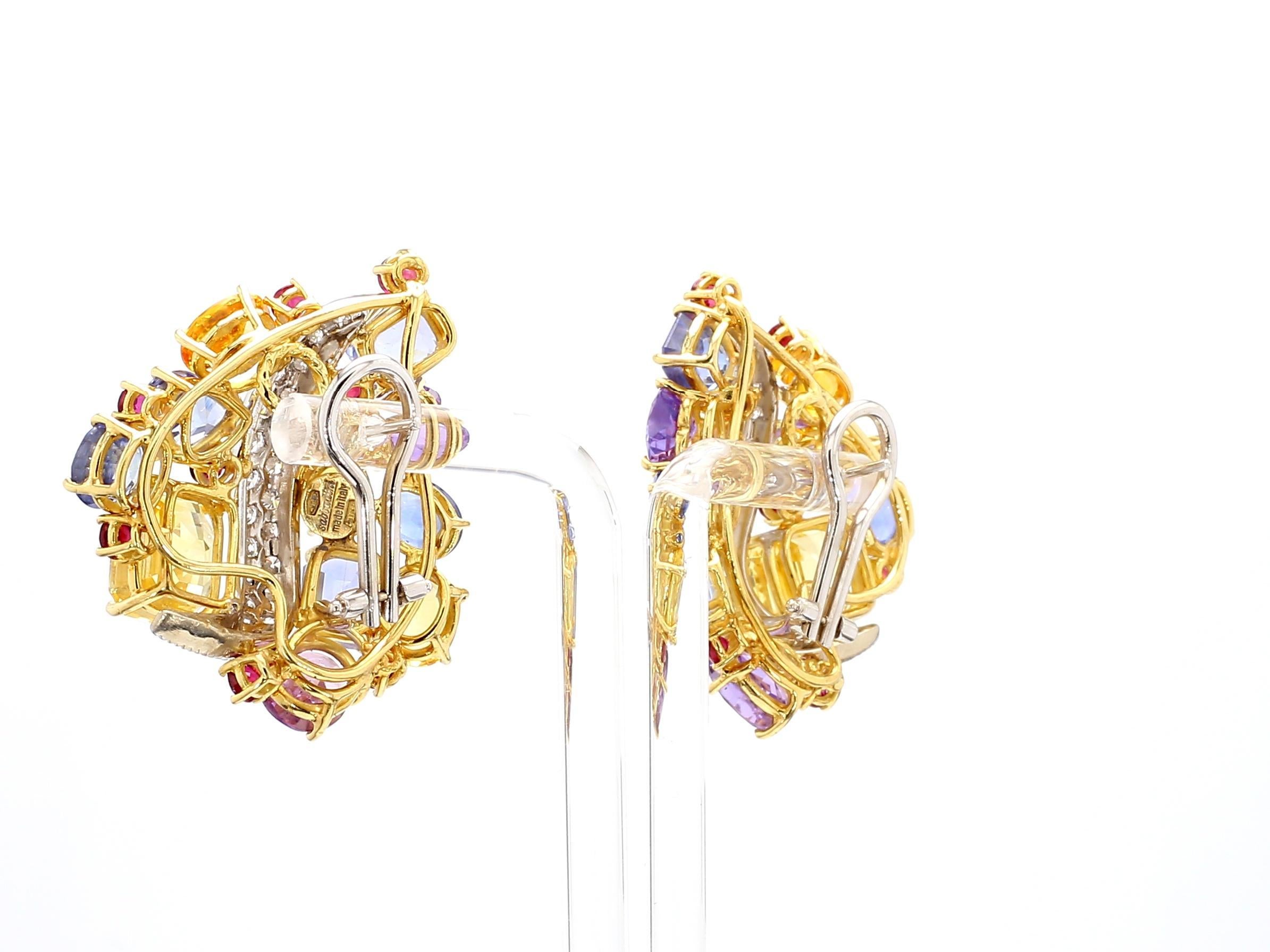 The Sabaddini Earrings are a vibrant display of luxury and craftsmanship. Featuring an array of colorful gemstones, these earrings are centered around the primary yellow sapphires, weighing a total of 50.0 carats. The sapphires exude a warm, golden