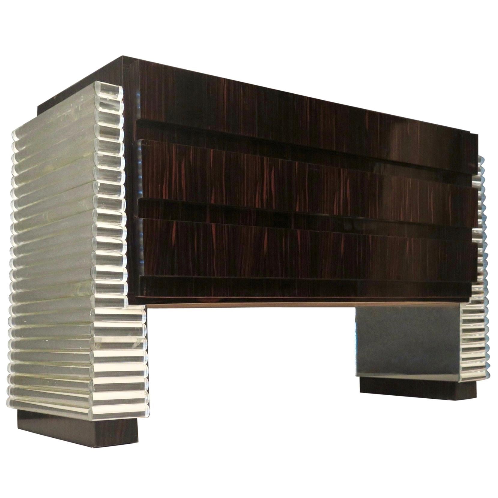 Sublime processing with glass, for an equally perfect dresser in its design; due to its alternating structure and the use of uncommon materials such as mirrored glass half-round and Macassar wood.

Body veneered in Macassar wood, with three