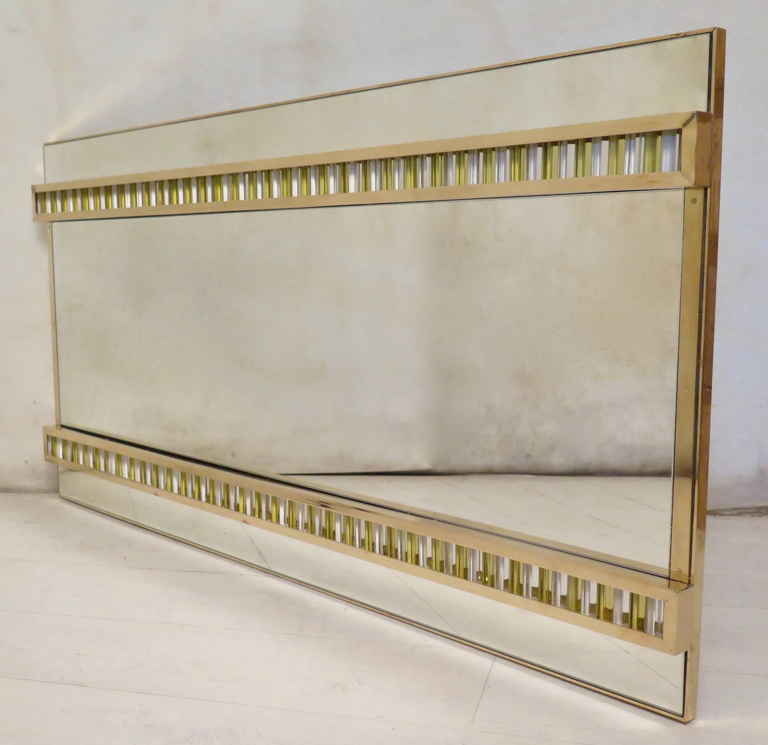 Feature and classic Murano wall mirror from the middle of the century.

Back structure in wood, with around a brass edge. Above are the three mirrors divided by two brass parts that cage the glass insert. The glass inserted inside the brass are in a