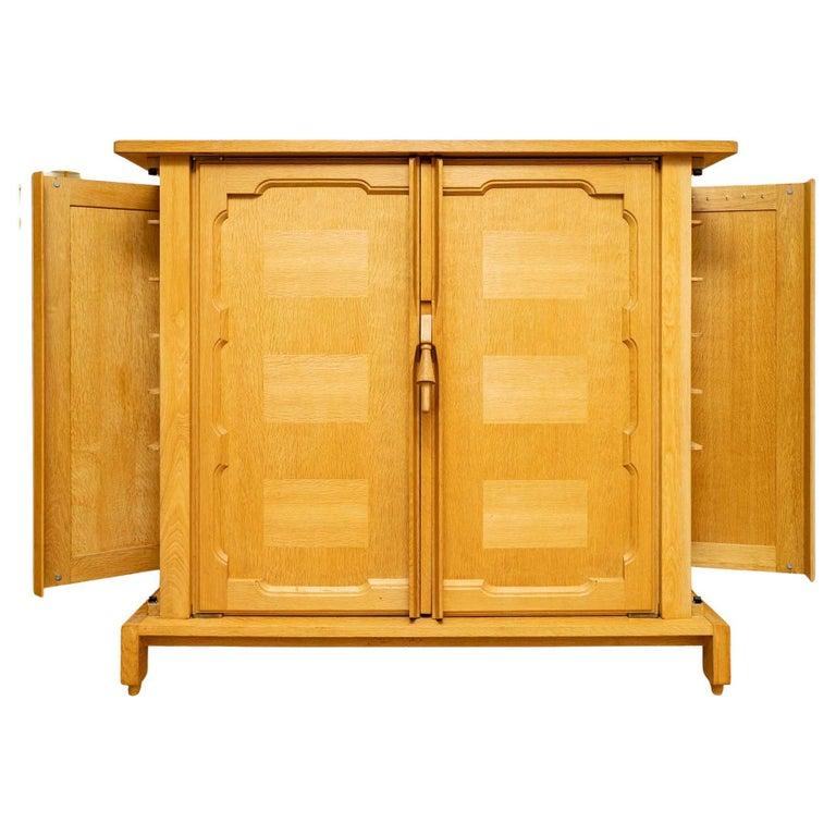 Rare cabinet model 'Bouvine' of Guillerme and Chambron of the 1950s.
The cabinet in solid oak opens on two front doors decorated on the outside with a slightly molded frame and a rectangular marquetry in oak gives a beautiful play of light to the