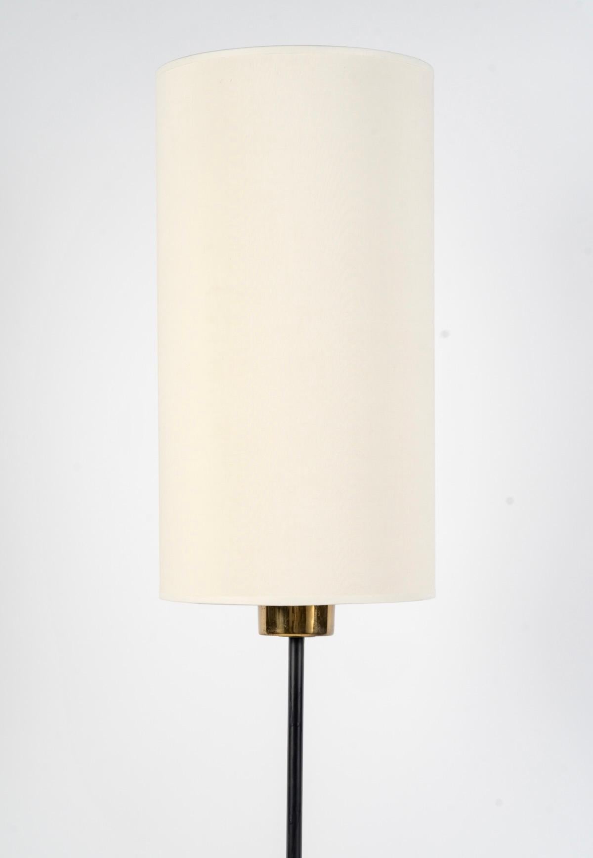 Composto da una base rotonda nera su cui poggia uno stelo rotondo in ferro battuto nero che forma una curva verso l'alto a metà altezza, decorato da un lato con una sfera in ottone dorato e dall'altro lato che sale più in alto e dotato di un
