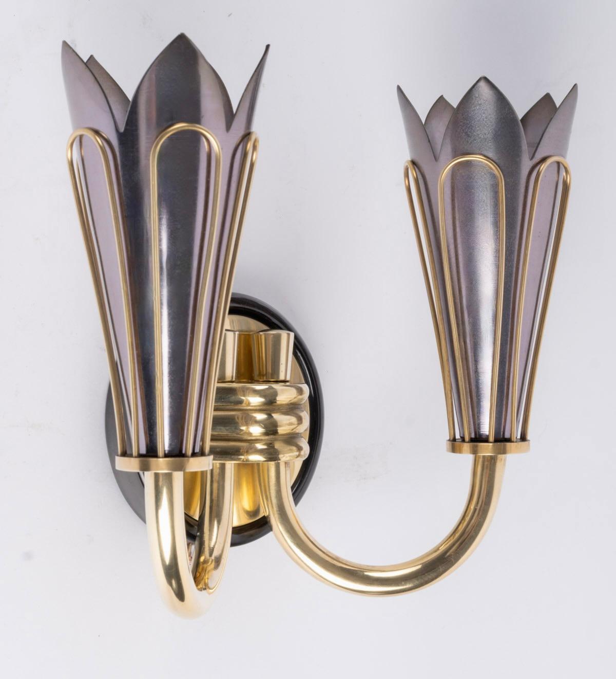 Paire d'appliques originales de 1950 par Marcel Asselbur.

Comprend un support mural rond en laiton noirci surmonté d'un cercle plus petit en laiton doré, supportant deux bras de lumière orientés vers le haut et maintenus en place à la base par