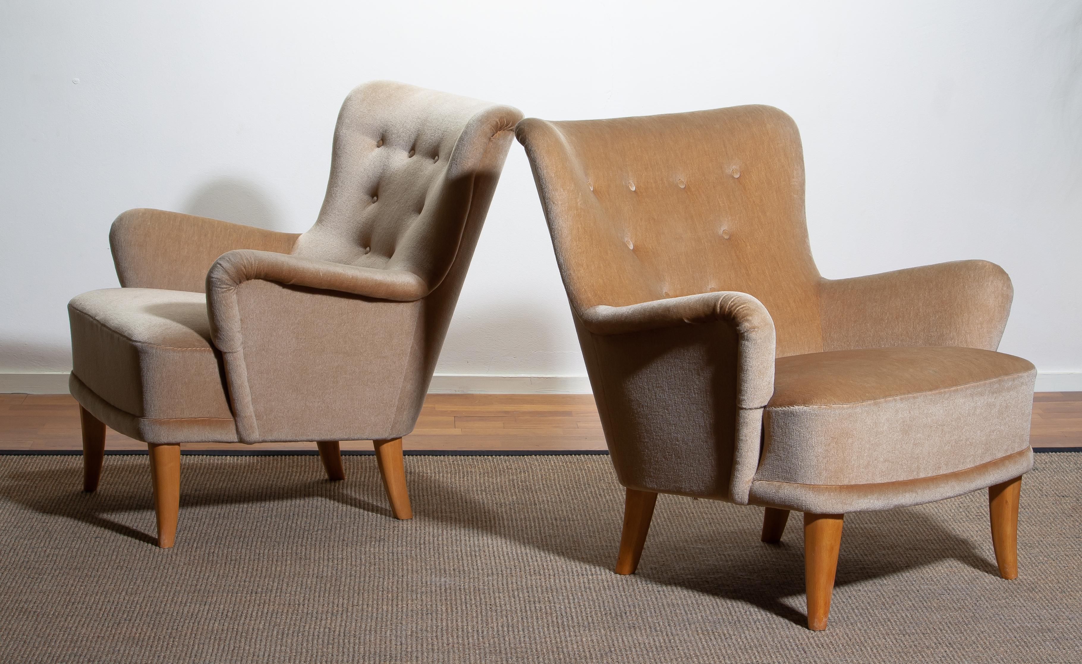 Set of two beautiful 1940s / 1950s lounge / club chairs covered with beige vetvet upholstery and beech legs designed by Carl Malmsten for O.H. Sjögren. Sweden.
The overall condition of the chairs is that they are in good and comfortable condition.