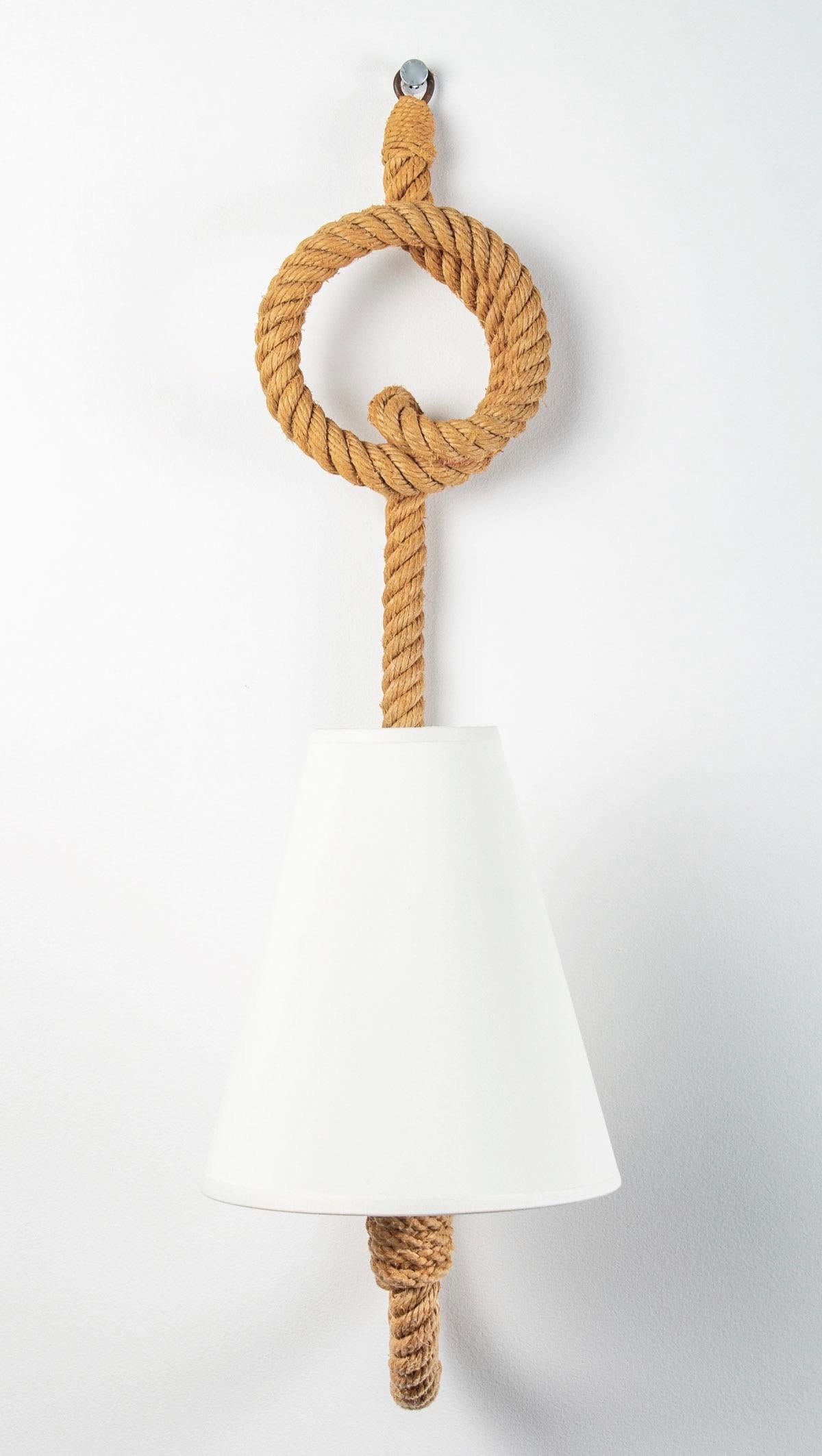 Composed of a luminous arm in rope decorated with a pretty loop ending by the wall attachment on the upper part, on the lower part the arm goes up to form the wall lamp, it is dressed with a lampshade of off-white color. 
1 bulb.

Adrien Audoux and