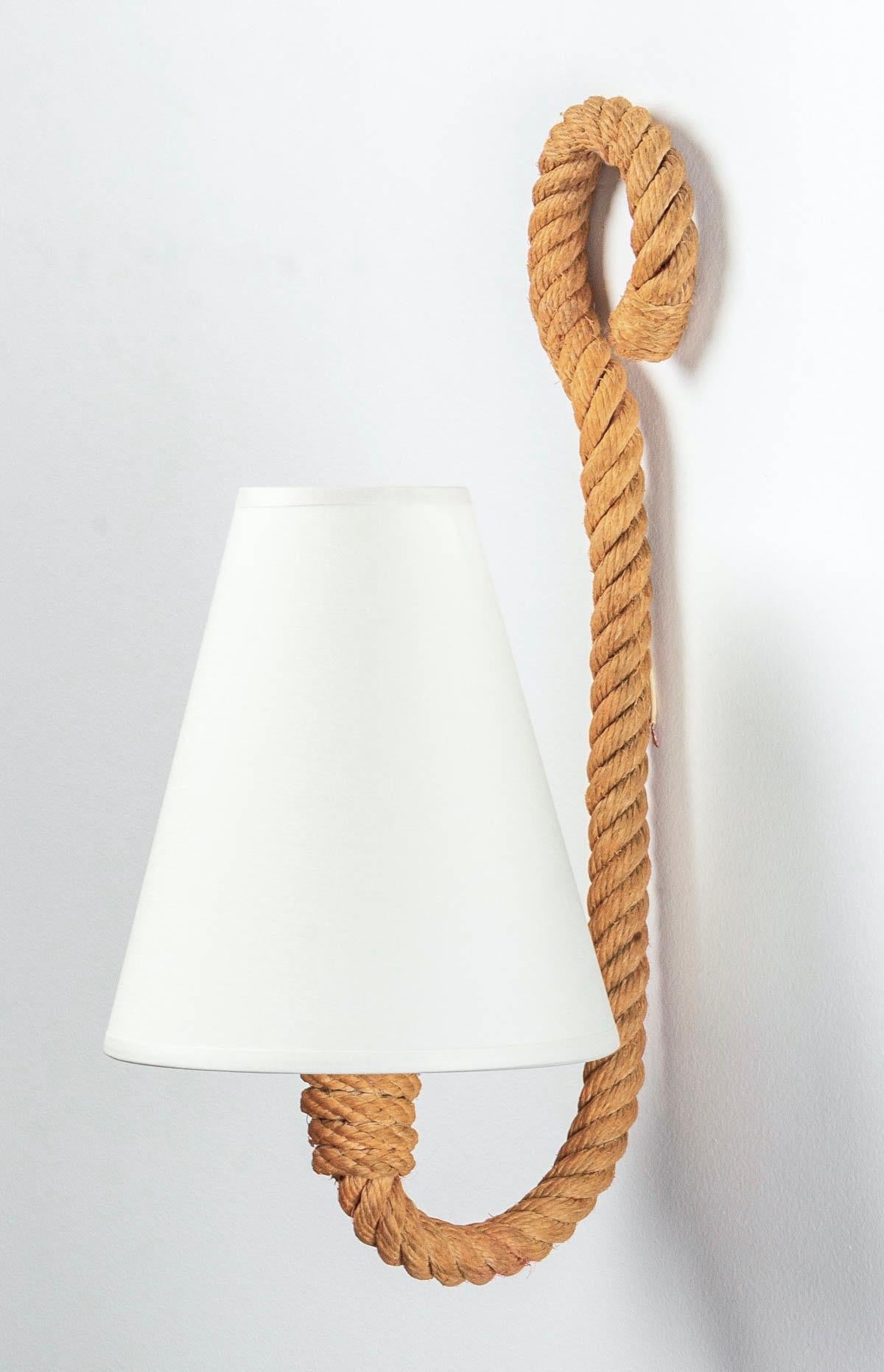 Composed of a luminous arm in rope decorated with a loop on the upper part, on the lower part the arm goes up to form the wall lamp, it is dressed with a lampshade of off-white color. 
1 bulb.

Adrien Audoux and Frida Minet are known for their work