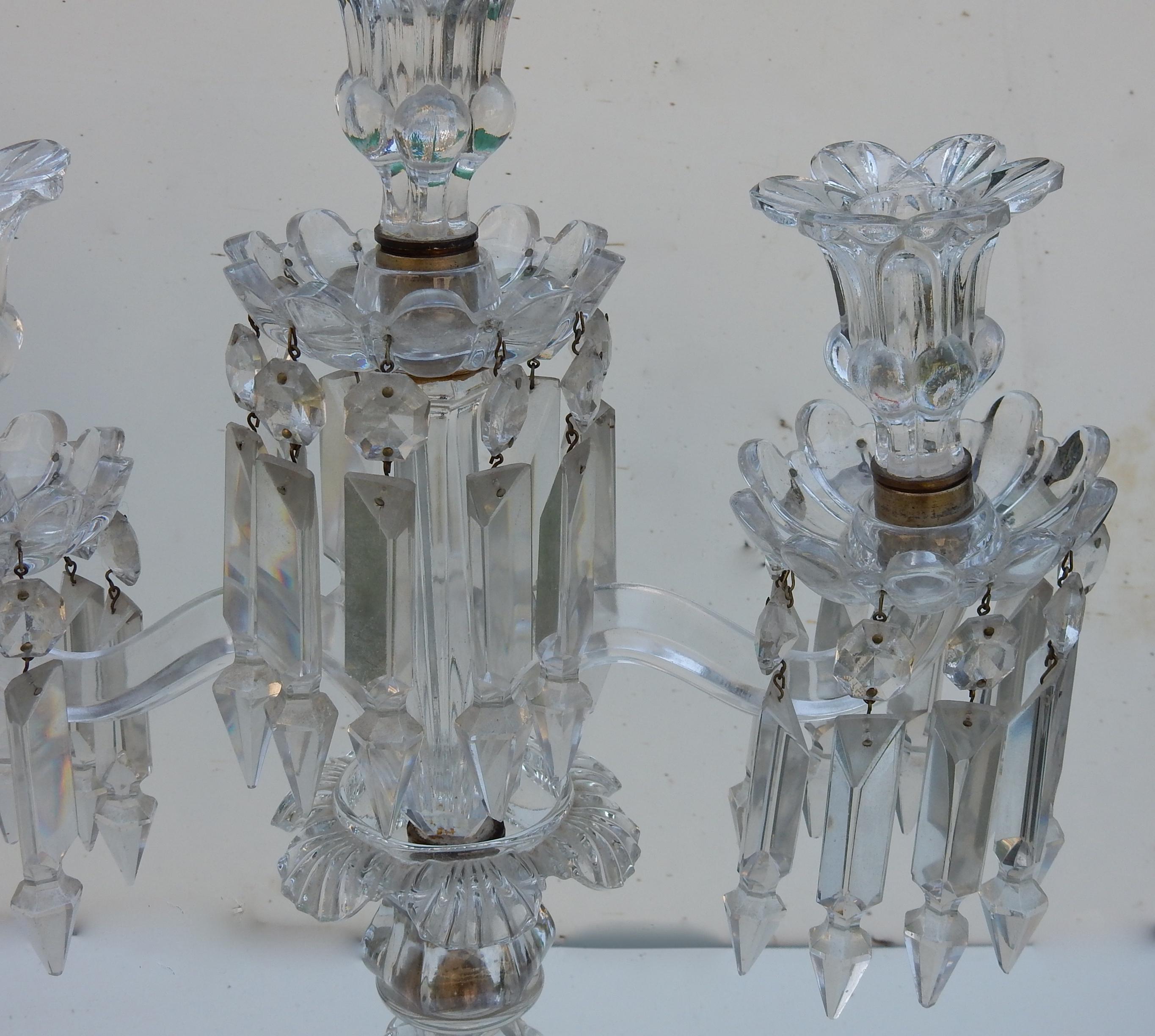 Pair of crystal candlesticks with 2 arms with prismatic pendants with a step to end in a point, round base decorated with bumps and round pearls. Signed Baccarat
Good condition.