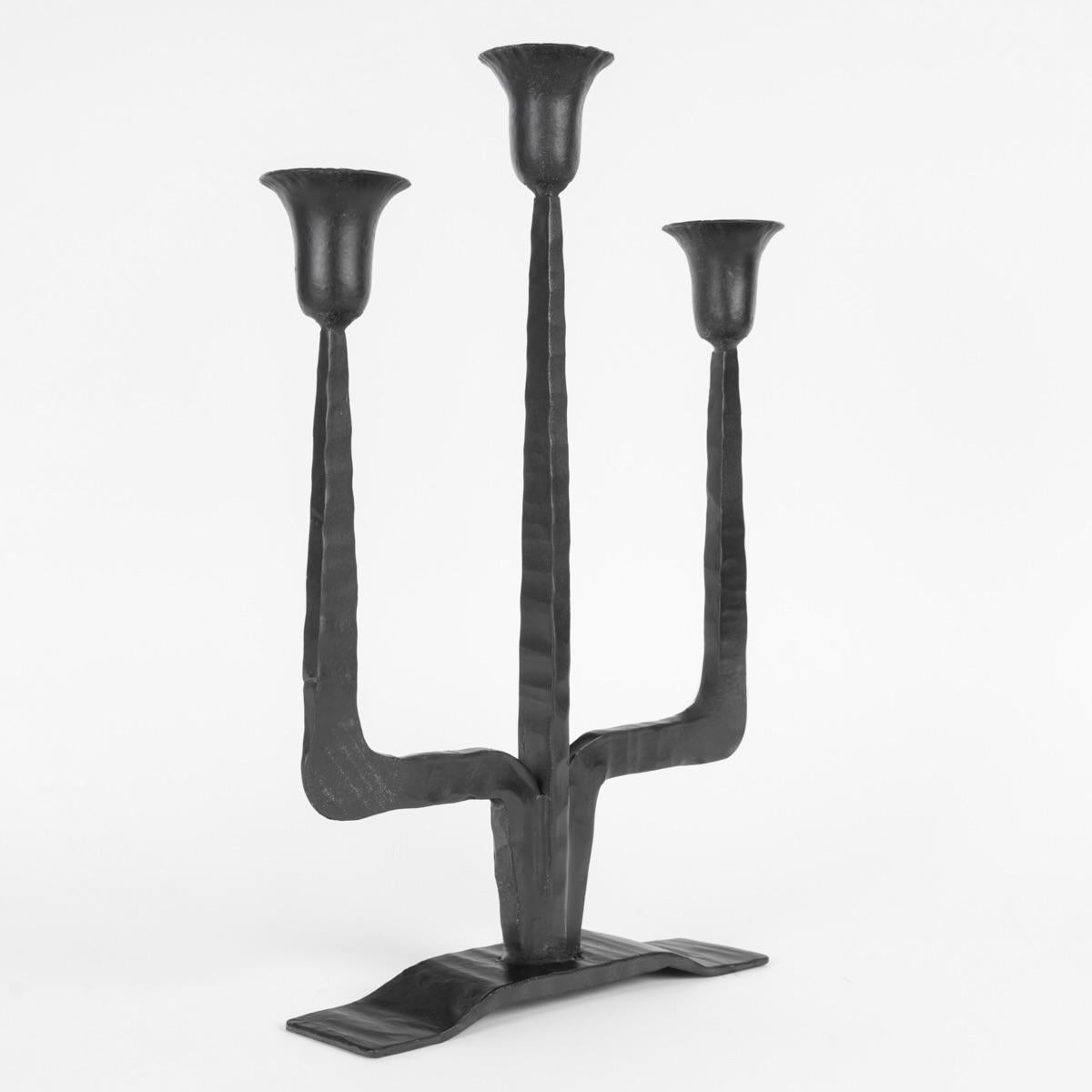 Composed of a base formed by a raised dish in the central part  on which rest 3 black wrought iron arms, the central one standing upright, the other two are distributed on either side, they also form a trapezoid-shaped elbow.
In the upper part, they