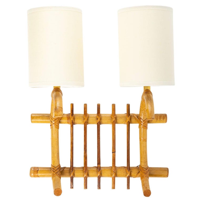 Composed of two bamboo rods placed vertically on the top and bottom of the sconce and two curved bamboo rods placed horizontally at each end of the sconce and decorated with thin bamboo rods placed vertically between the two light arms.
All the