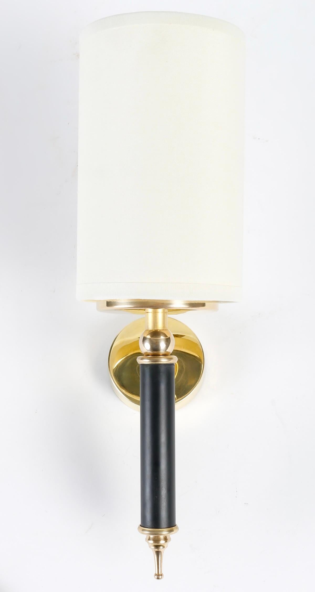 Pair of wall sconces Maison Arlus of the 1950s.
Composed of a cylindrical arm in blackened wood decorated on the lower part with a gilded brass ball ending in a drop and on the upper part with a gilded brass ring on which is placed a light source