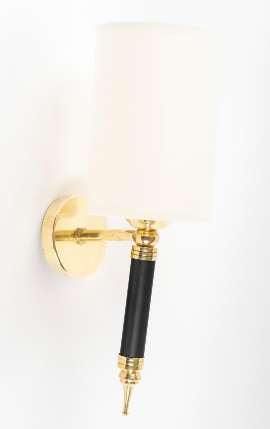 Pair of wall sconces Maison Arlus of the 1950s.
Composed of a cylindrical arm in blackened wood decorated on the lower part with a gilded brass ball ending in a drop and on the upper part with a gilded brass ring on which is placed a light source