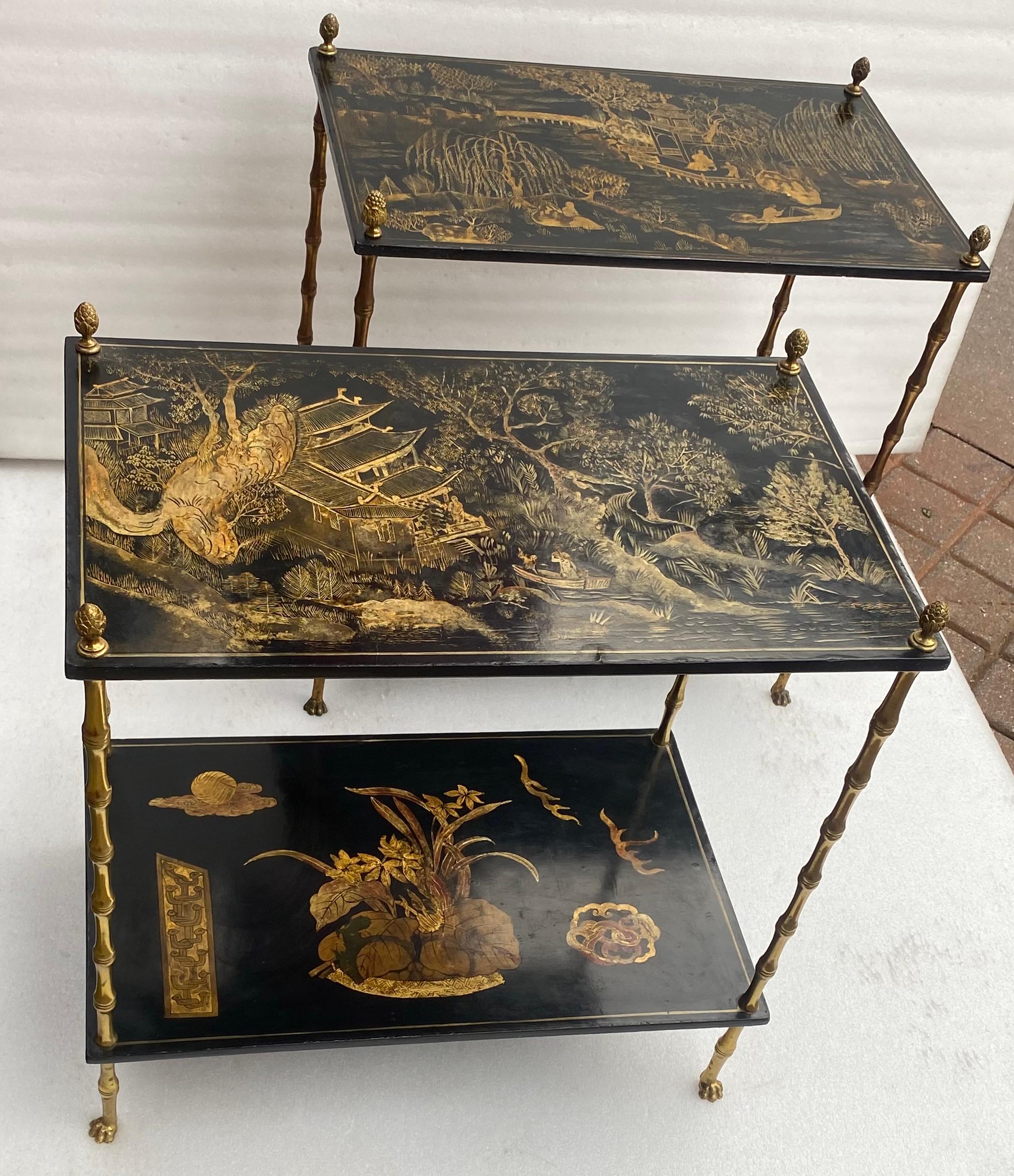 Paire de tables en bronze doré à décor de bambou, pieds griffes avec plateaux en bois laqué chinois à décor de paysage, pagode, oiseaux, pêcheur sur une barque, pommes de pin à l'extrémité des montants.
Label sur un plateau
Circa 1950, condition