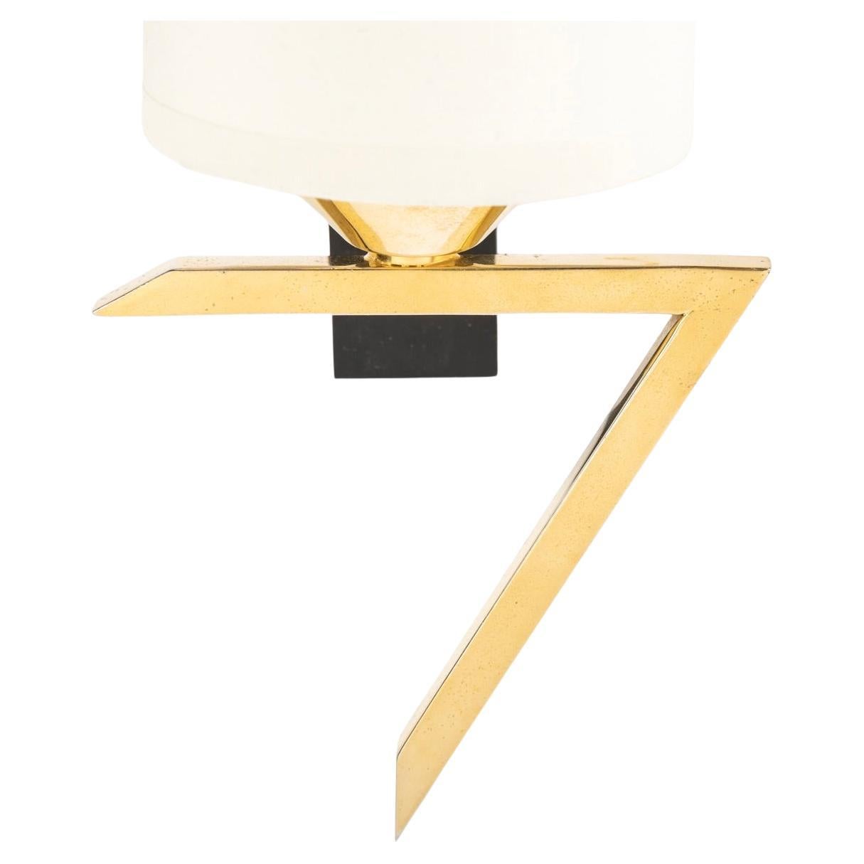 Composed of a black rectangular wall support on which rests the gilded brass square-section light arm forming an elbow on which rests a cylindrical shade in off-white cotton reworked to match and highlighted by a gilded brass cup.

1 arm light