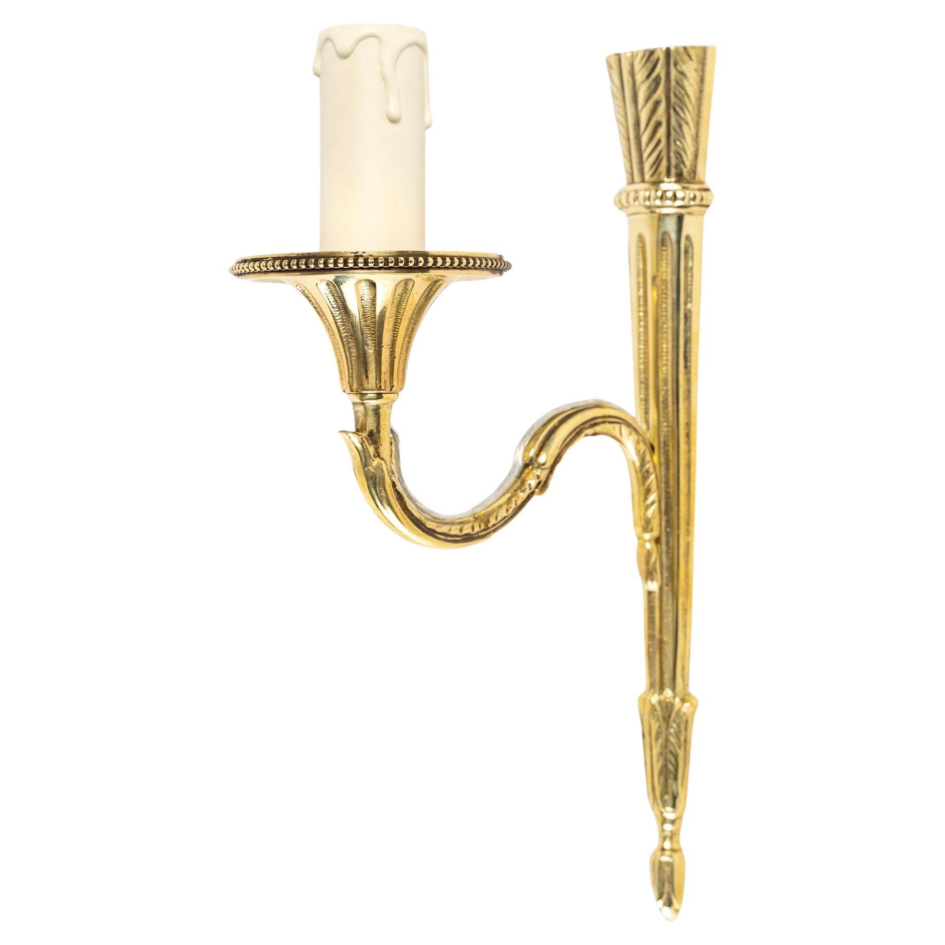 Composed of an arm in gilded bronze decorated in the upper and lower parts with neo-classical attributes in the Louis XVI style, on which is placed a rising arm of light, it is dressed with an illuminating candle and underlined by a pretty basin,
