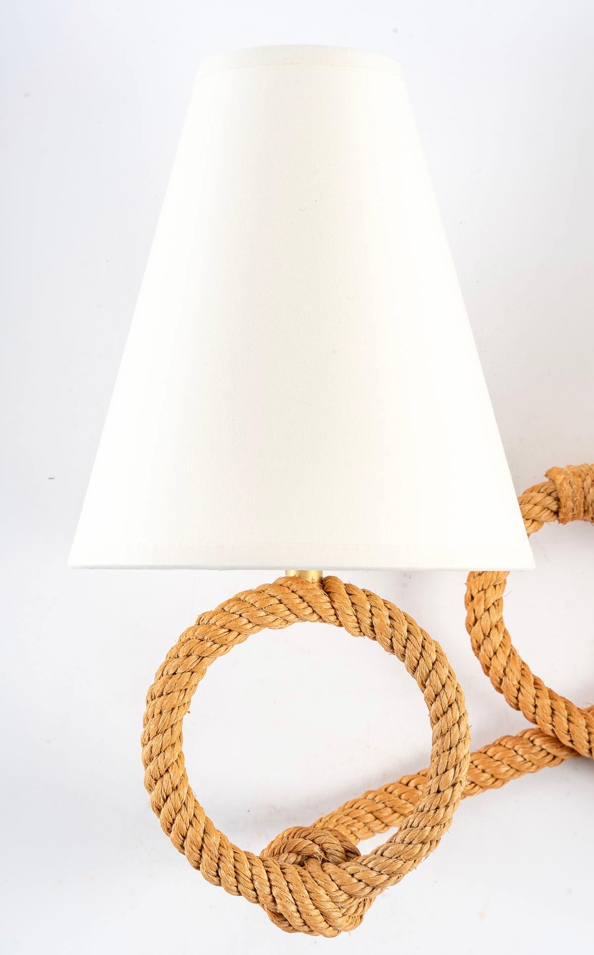 Composed of a round wall base formed by a rod of rope crossed on the lower part, the two ends of the rope are embellished with two arms of light placed in the upper part formed by two rounds of rope distributed on each side of the wall lamp, it is