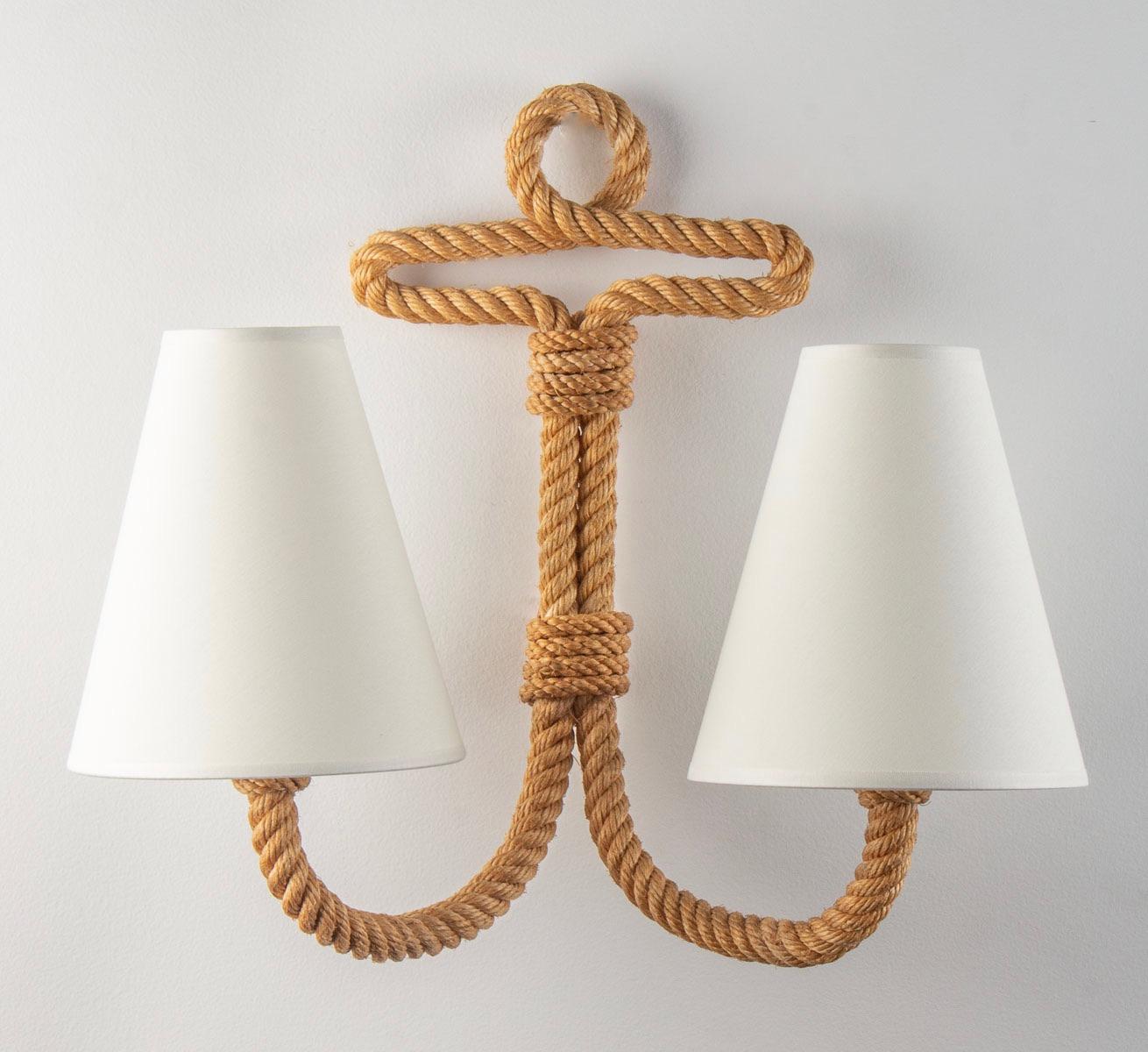 Composed of a single rope in the form of ink on the upper part and on the lower part by two arms of light going up distributed on each side of the wall lamp, they are dressed with lampshade of off-white color.
2 bulbs per sconce

Adrien Audoux and