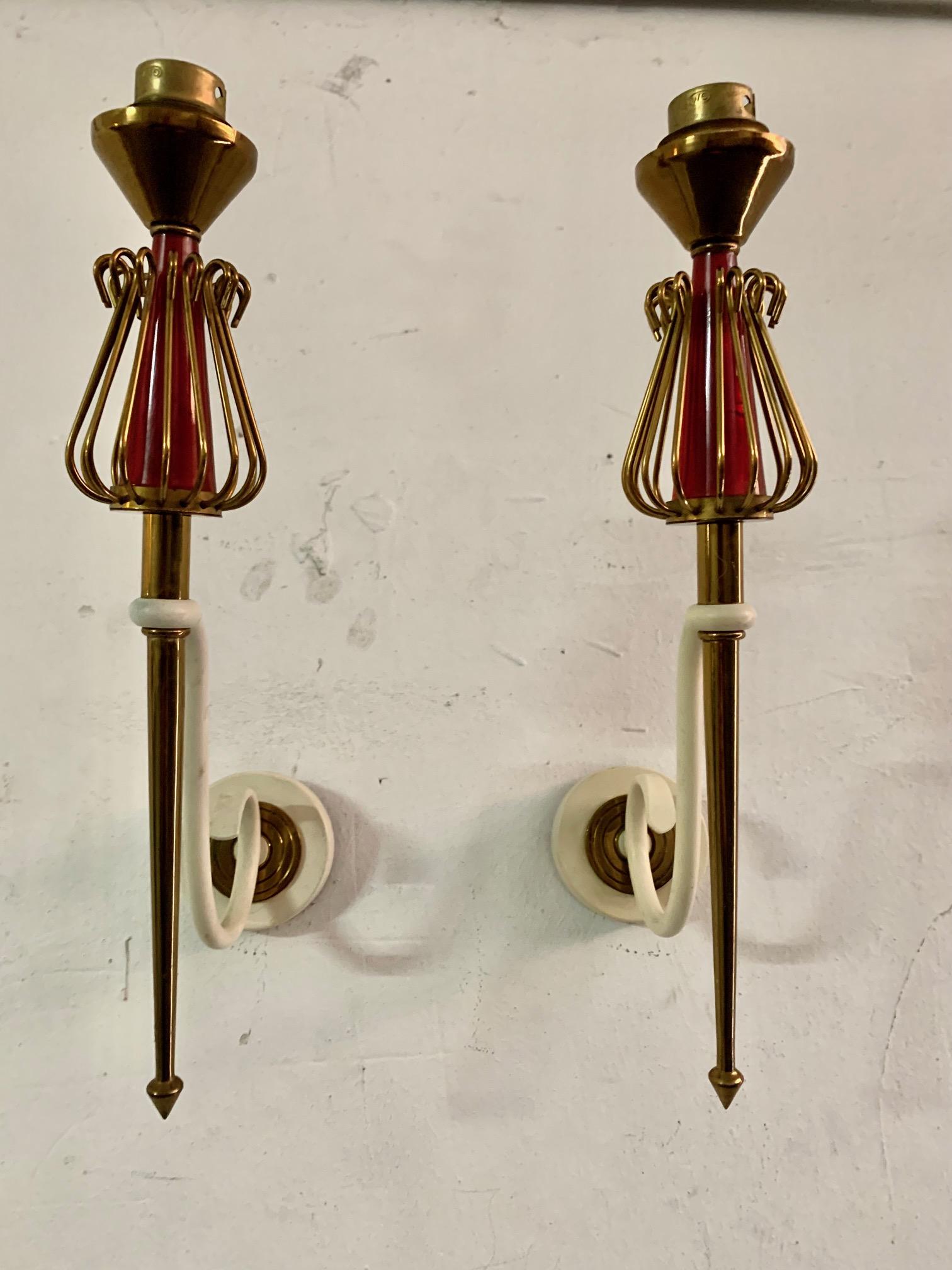 Large pair of 1950's sconces from the Maison Lunel.
Composed of a round wall base on which an arm is placed forming a volute in off-white wrought iron, from which a point-shaped golden brass arm emerges and in its upper part it has a brass wire