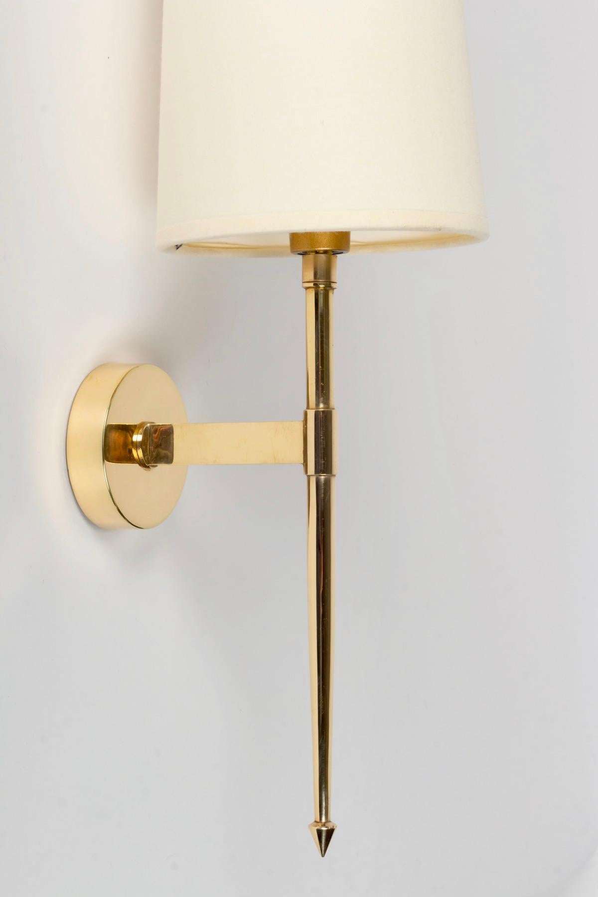 Pair of wall sconces in golden brass, elegant and minimalist.

It is composed of a round wall plate on which is placed in front of a rod acting as an arm of light, it is placed vertically and decorated on the lower part of a point and on the upper