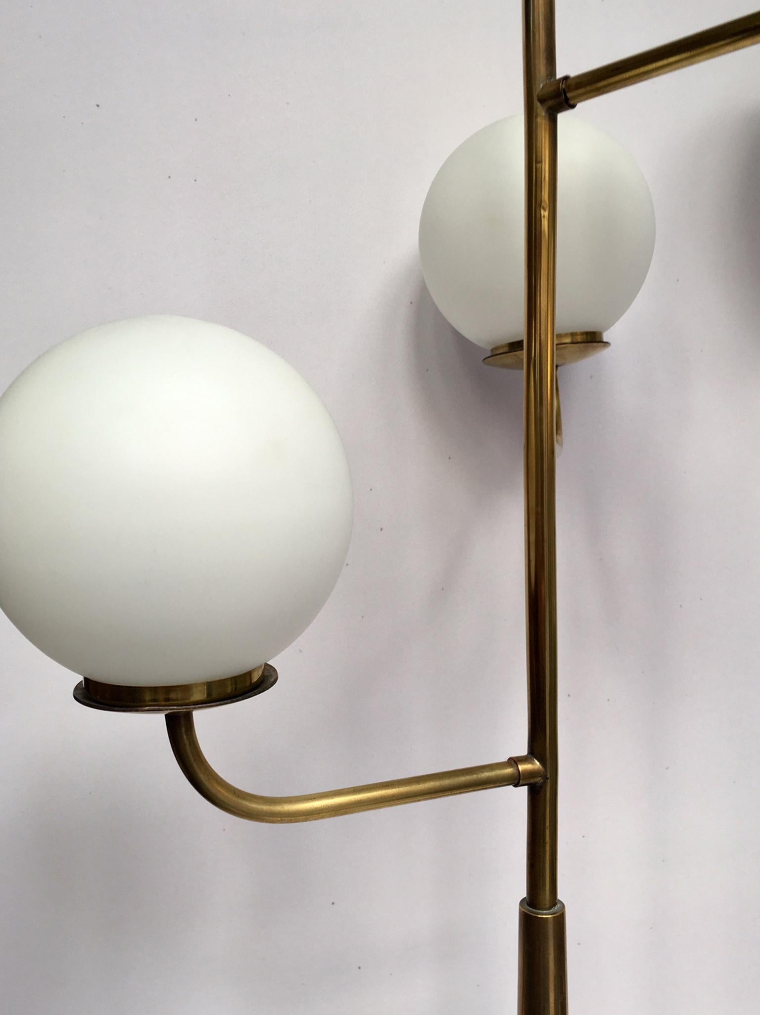 Triple light floor lamps with tripod foot in solid brass, on which is placed a conical mahogany varnished trunk, both sides of which are set brass sconces.
On each arm is set with white original opaline.
Wired to the EU standards, electrical