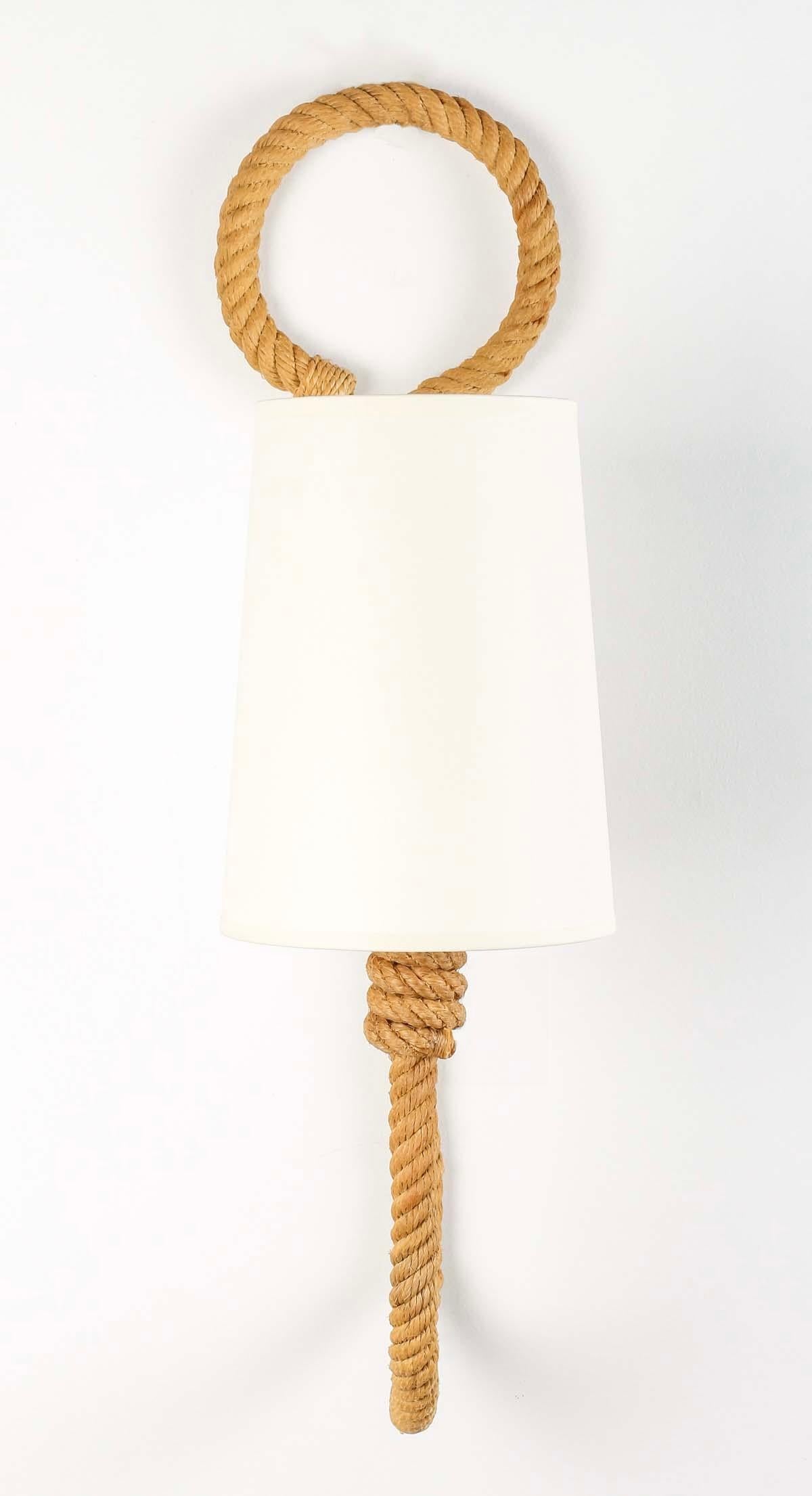 Composed of a central rope stem embellished with a loop on the upper part, on the lower part the stem rises to the front to form the light arm clad with an off-white cotton trapeze-shaped shade.
1 bulb per sconce.

Adrien Audoux and Frida Minet are