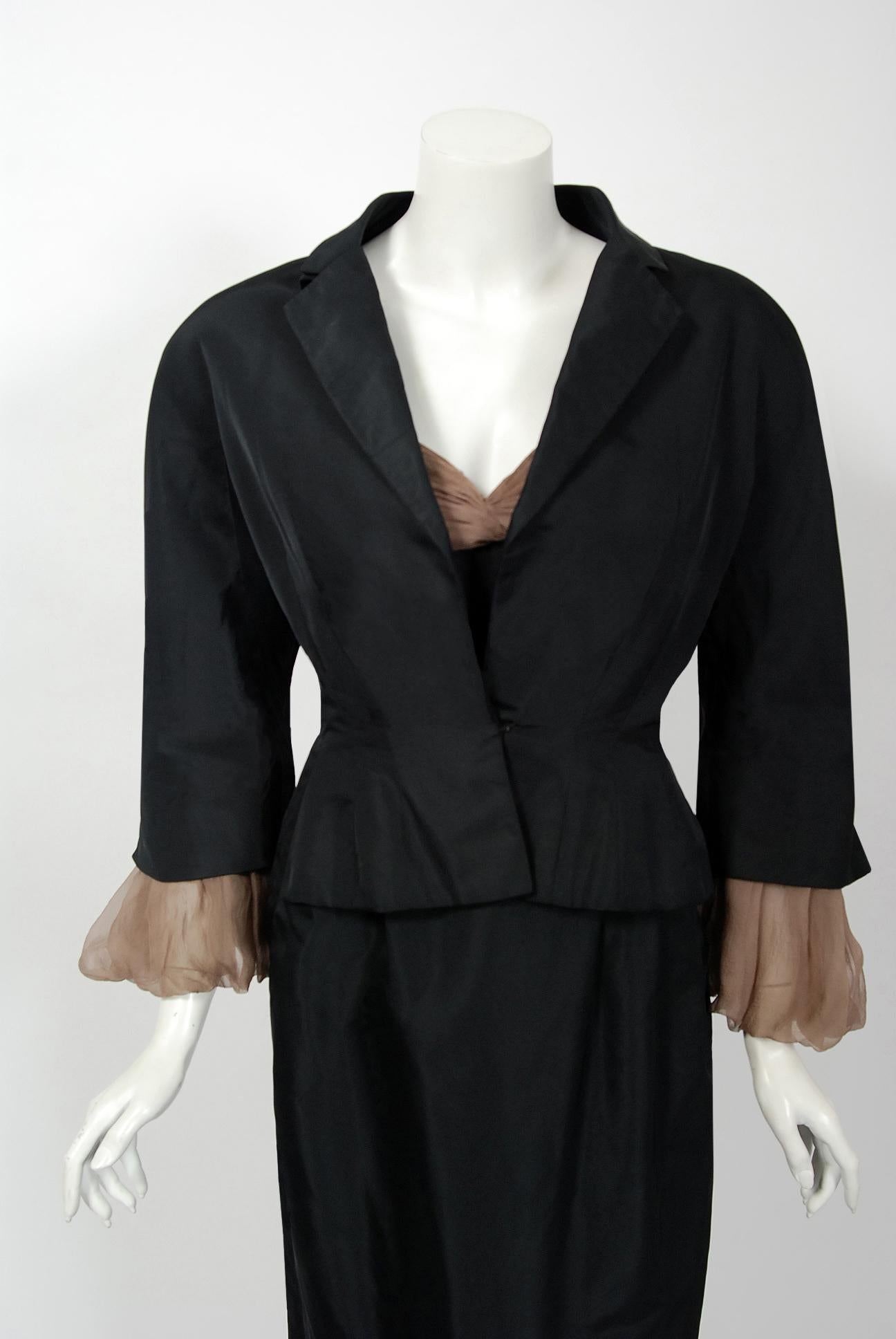 Gorgeous Pierre Balmain black silk and nude chiffon hourglass cocktail dress dating back to his 1950 collection. Balmain created a very sculptural quality which was always allied with a ladylike essence. His garments have a body and a shape of their