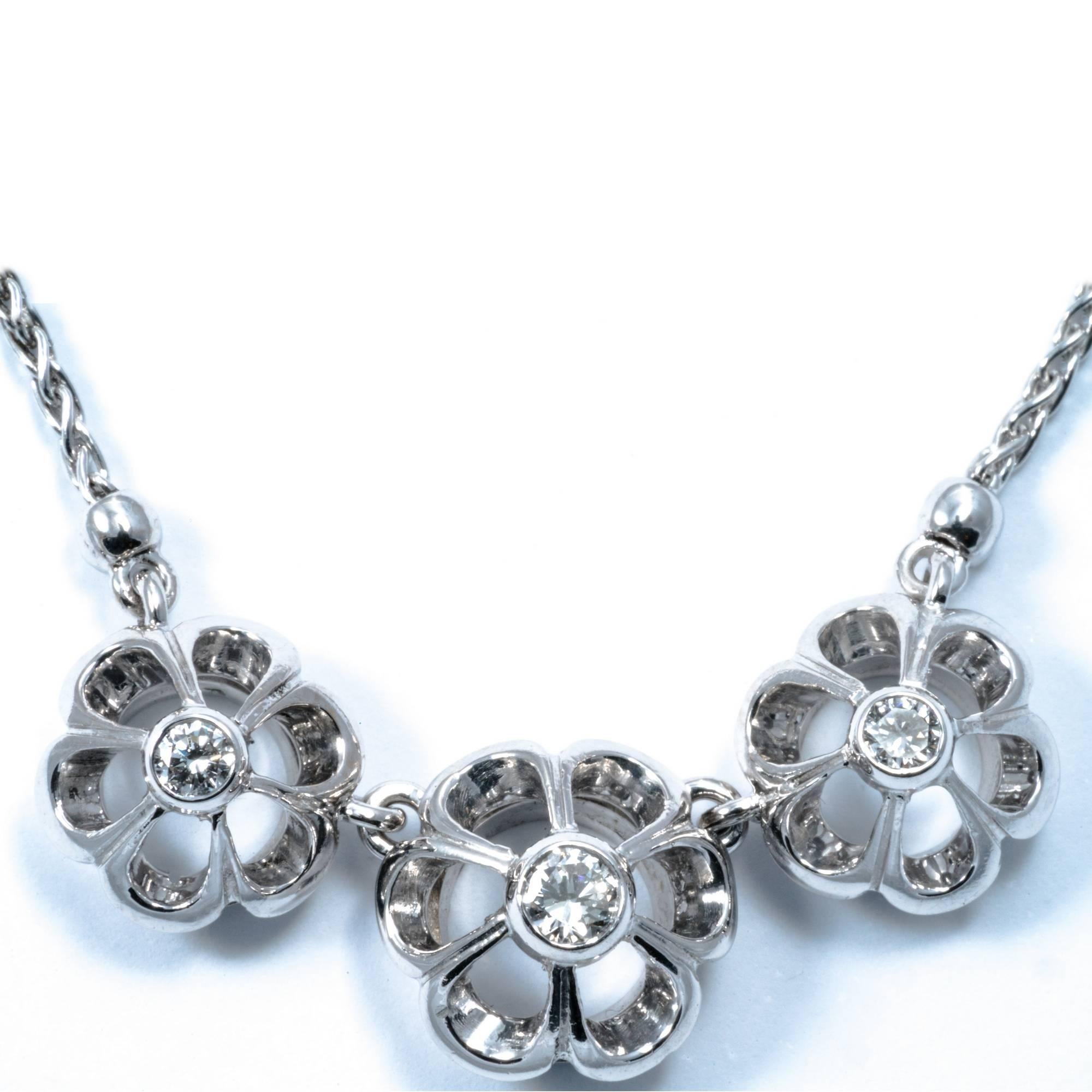 This 1950 retro necklace features 3 stylized flower enlightened by diamonds at the centre. Approximate diamond total weight is carats 0.25