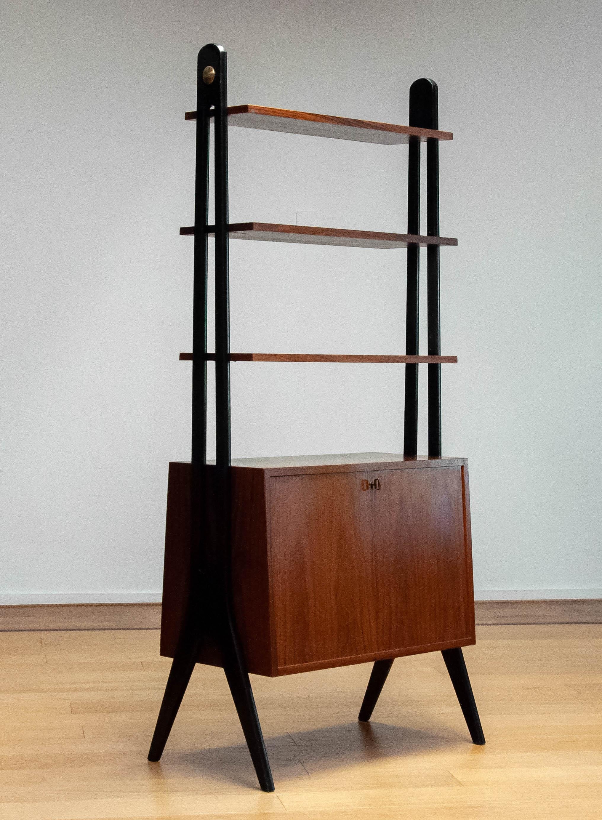 Absolutely beautiful and rare Scandinavian moderen bookcase which can be used as a room divider as well made by Treman in Sweden in the 1950s.
This cabinet is made of Rosewood / Rio Palissander combined with black lacquered stands made of beech. The