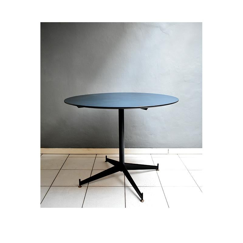 Mid-Century Modern, round vintage dining table for four people.
The table has a petroleum blue formicac top with black iron structure with adjustable brass feet.
The table was manufactured in Italy around the 1950s
Given its size and simple and