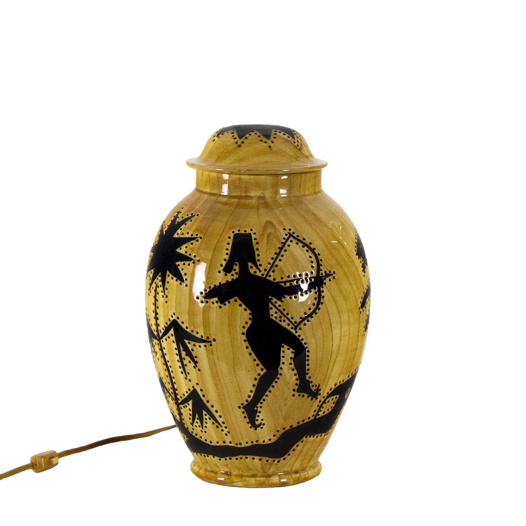 Covered pot forming a lamp, perforated ceramic decorated with fake olive wood and a hunting scene in Africanist style.
Design: Grandjean - Jourdan

France, Vallauris circa 1950.