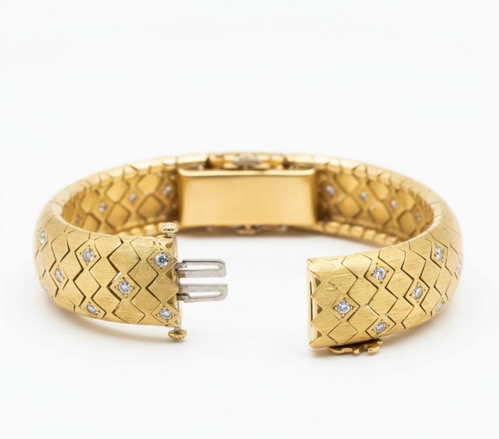 This exquisite vintage bracelet from the 1950s exemplifies the elegance and craftsmanship of mid-century fine jewelry. Crafted in 18K yellow gold (hallmarked and tested), the bracelet weighs 60 grams and features a substantial, luxurious