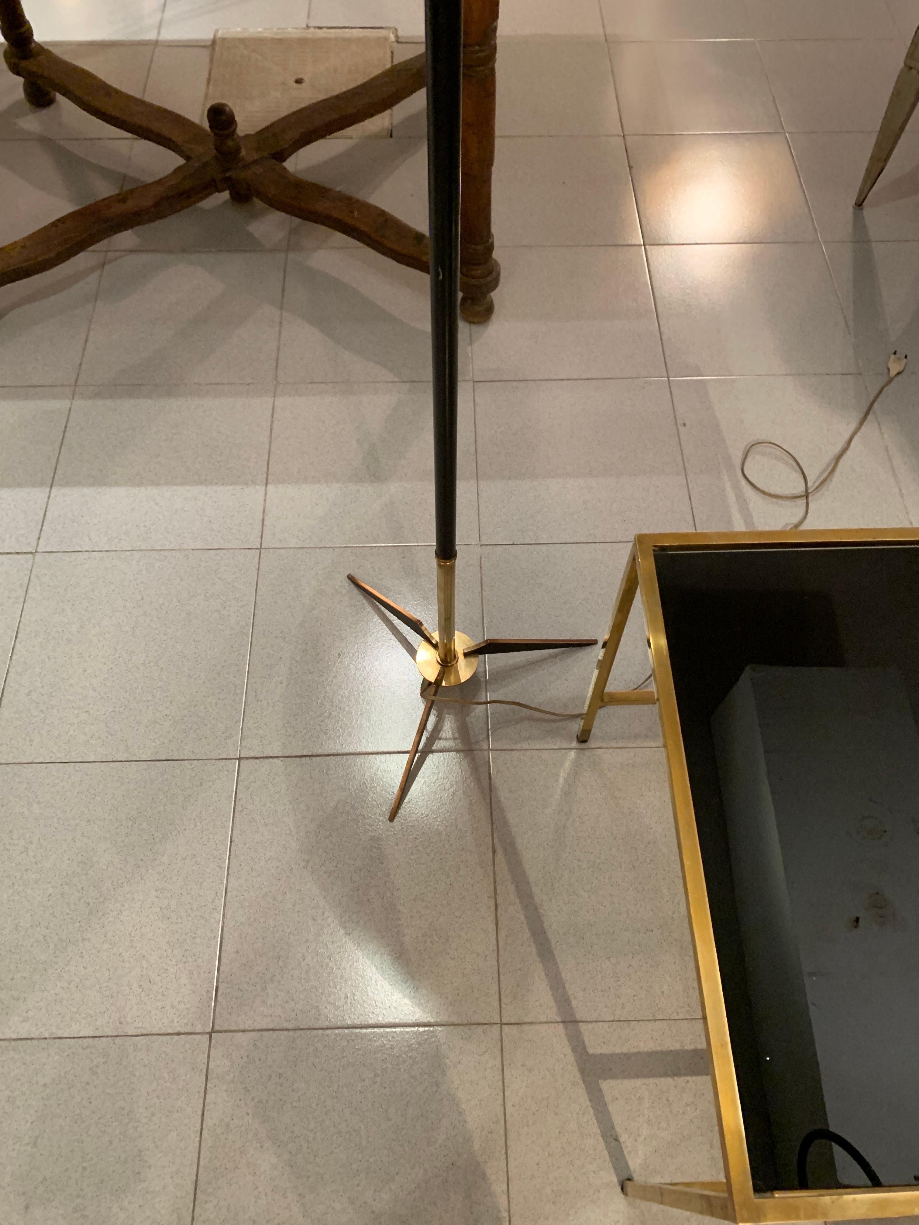 Eine schöne Lampe aus den 1950er Jahren von Maison Arlus, bestehend aus einer zentralen Säule aus schwarz lackiertem Holz, die auf einem runden Sockel ruht, aus dem drei goldene und schwarz lackierte Beine herausragen, die auf goldenem Messing