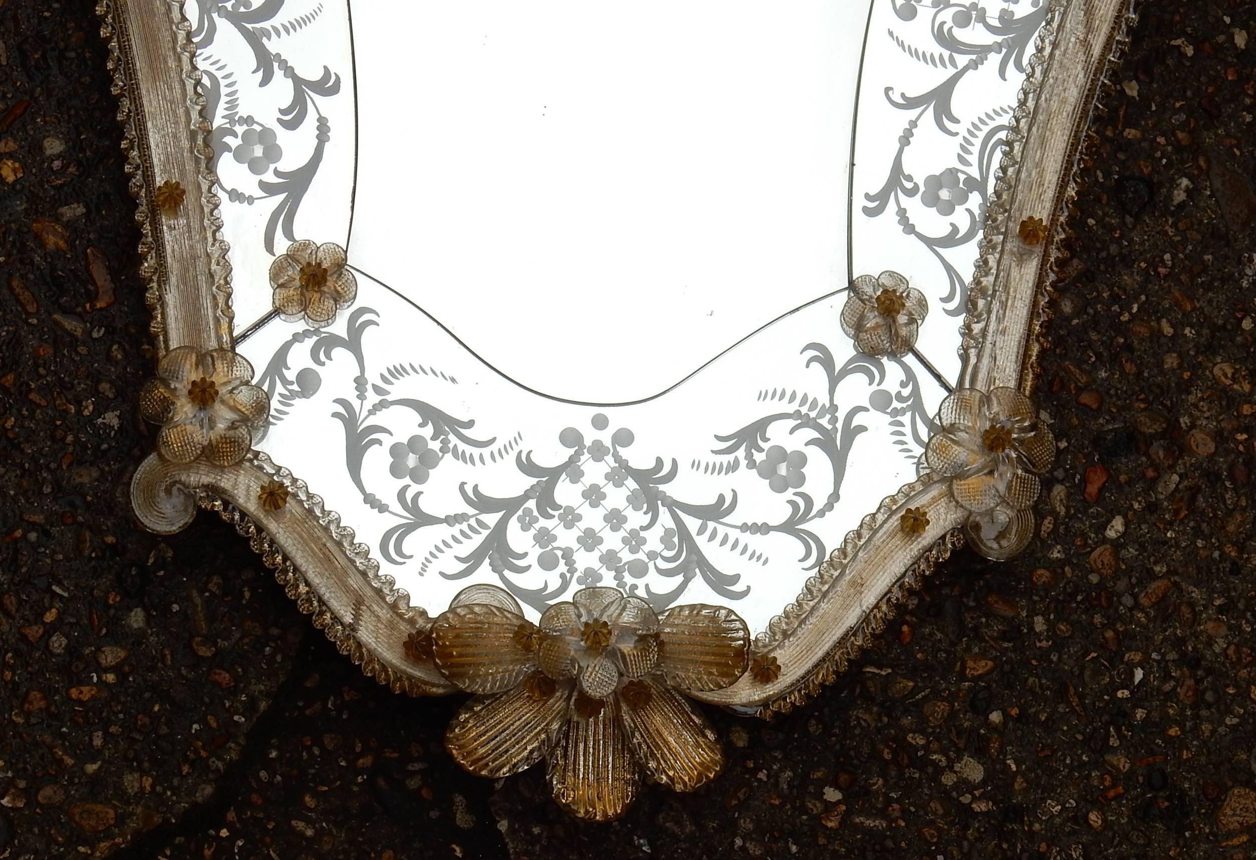 Murano mirror with leaves and golden flowers has the sheet of gold in inclusion, circa 1950-1970, good condition, central mirror is beveled. Measures: H 87 x 59 cm.