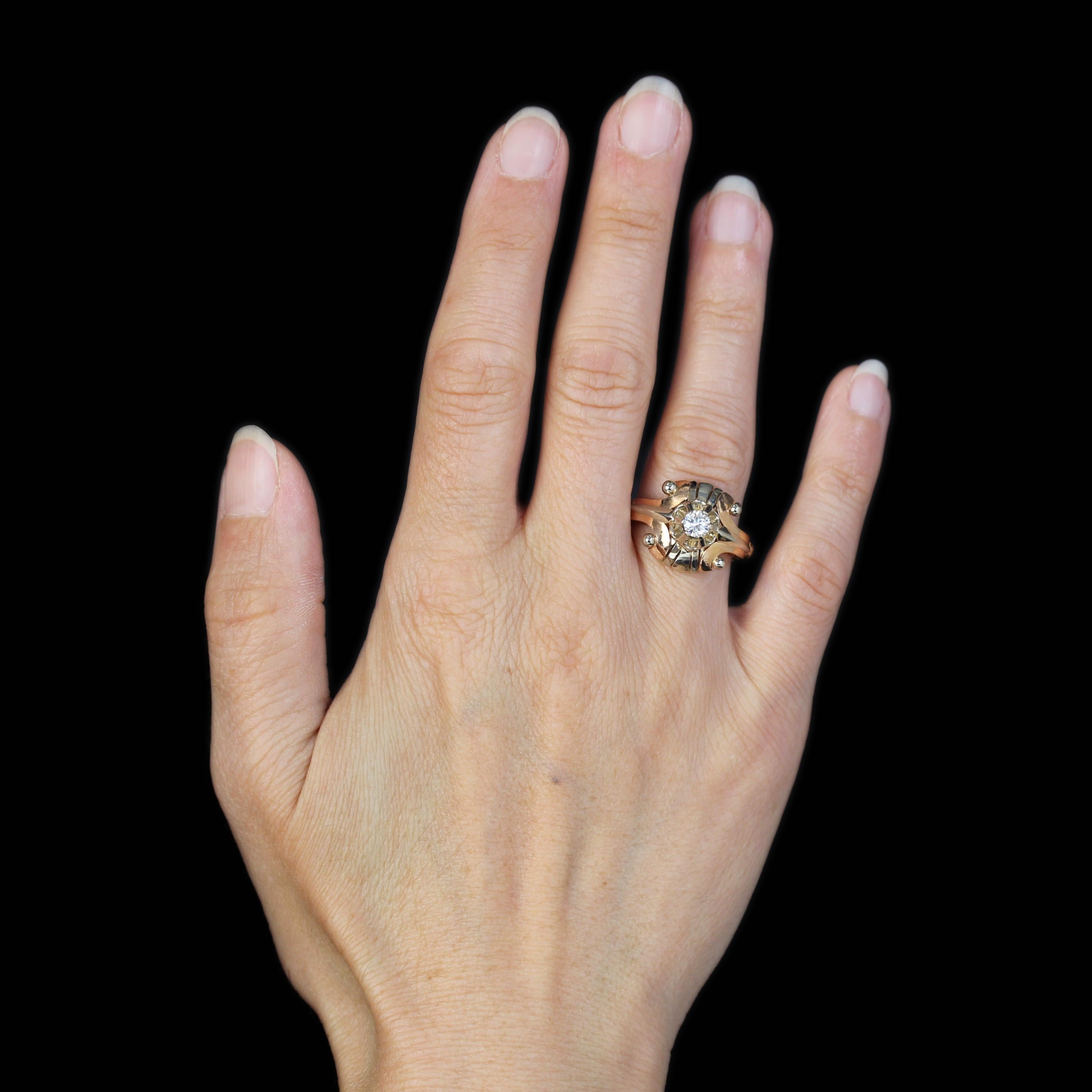 Anello in oro rosa e bianco 18 carati.
Questo anello antico è incastonato con un diamante dal taglio brillante. Su entrambi i lati, sul bordo e all'inizio dell'anello, un motivo a freccia che separa due volute è rifinito con perle in oro bianco che