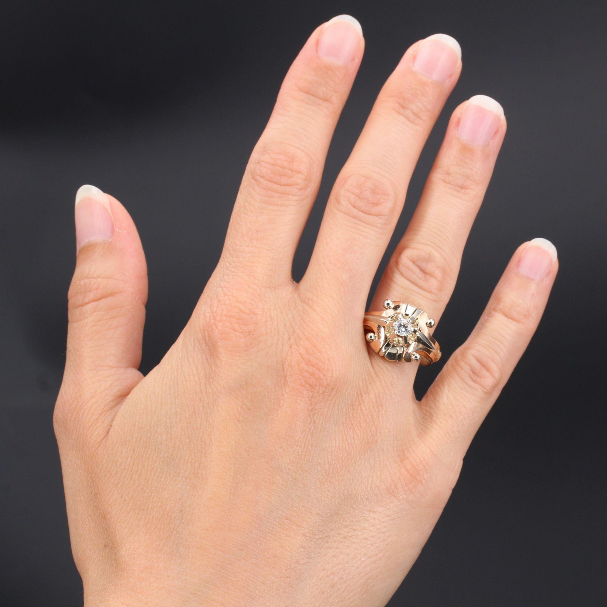 Ring in 18 karat rose and white gold.
This antique ring is set with a brilliant-cut diamond. On both sides, on the edge and on the start of the ring, an arrow pattern separating two volutes is finished with white gold pearls giving the impression of