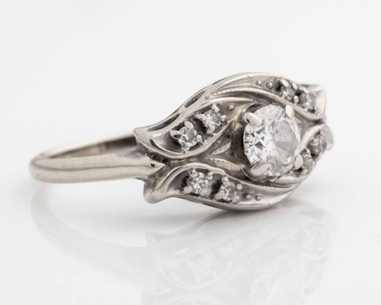 1950s 0.60 cttw Diamond Engagement Ring - 14k White Gold

The Round Brilliant Diamond center stone is securely set in an elevated four prong frame. 
Eight single cut, prong set diamond accent stones are set in pairs at each corner of the ring. 
The