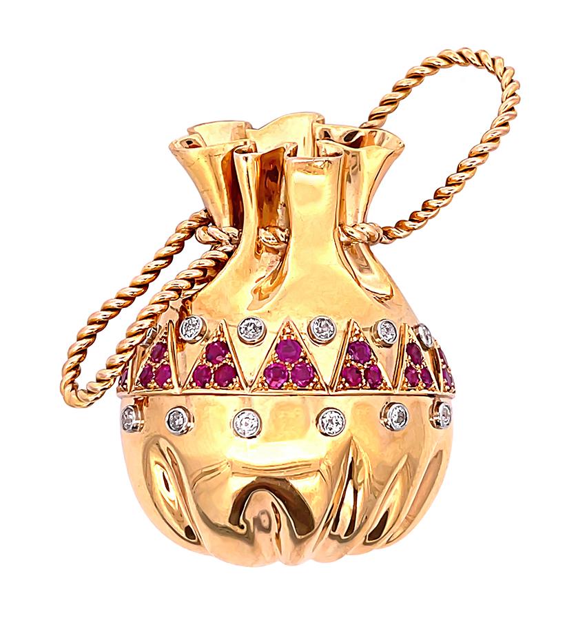 This is a charming 18k yellow gold money bag pin from the 1950s. The pin is set with sparkling old mine cut diamonds that weigh approximately 0.80ct. The color of these diamonds is G-H with VS2 clarity. The diamonds are accentuated by round cut ruby